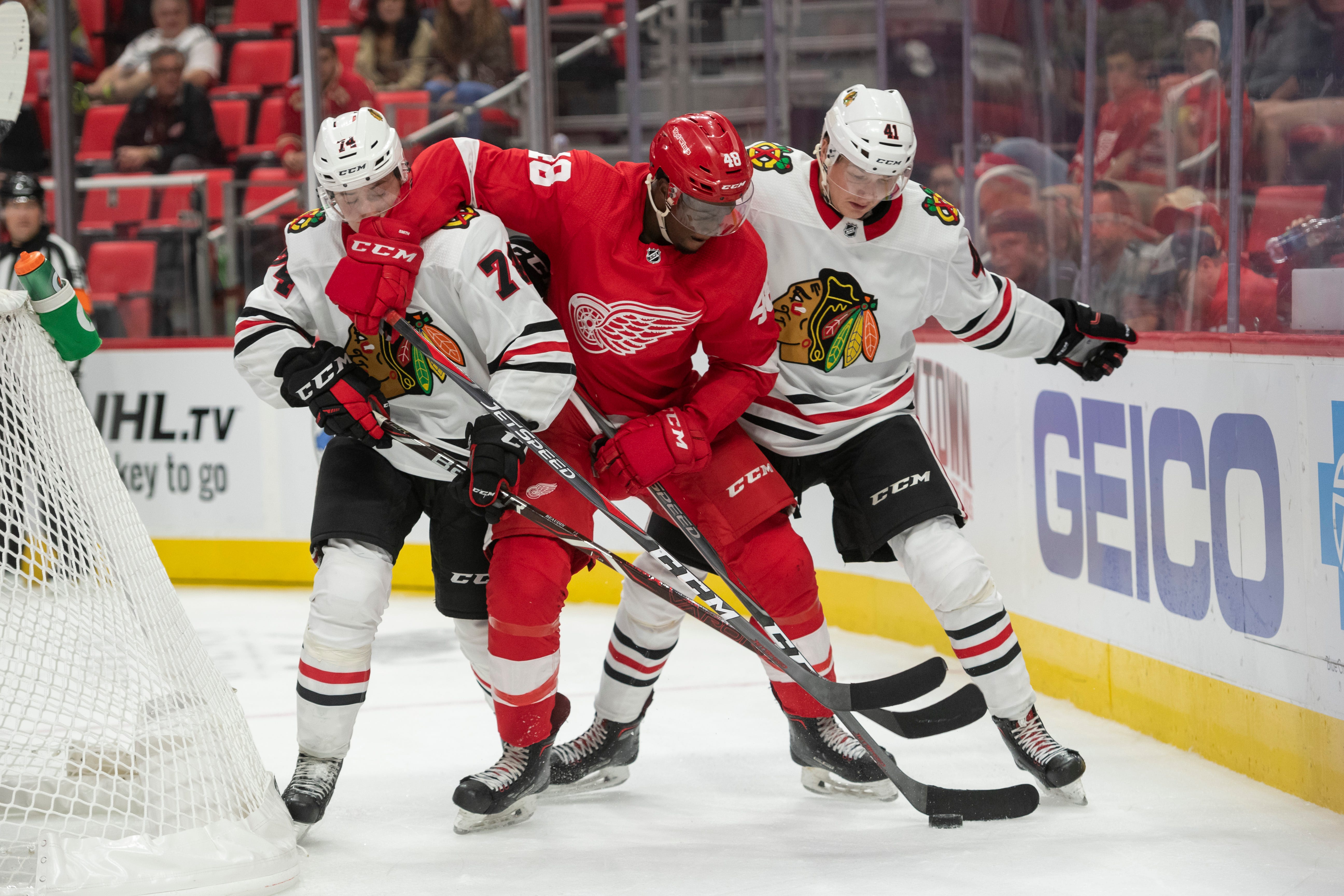 Detroit right wing Givani Smith battles for the puck with Chicago defenseman Nicolas Beaudin, left, and defenseman Joni Tuulola in the third period.