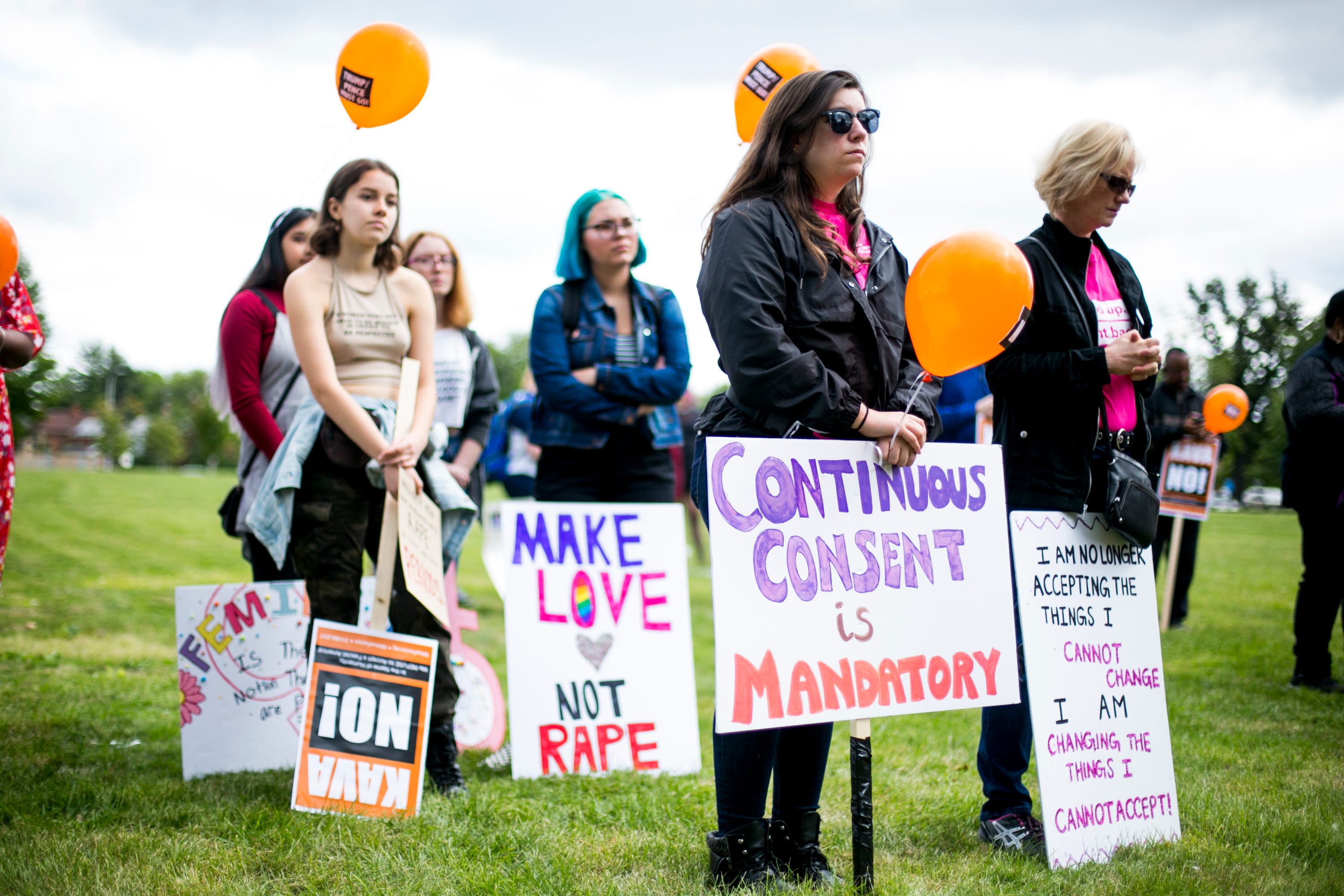 People hold signs during the Slut Walk at Palmer Park in Detroit on September 22, 2018.  The march and rally brought out about 70 demonstrators protesting sexual violence and other forms of aggression against woman.