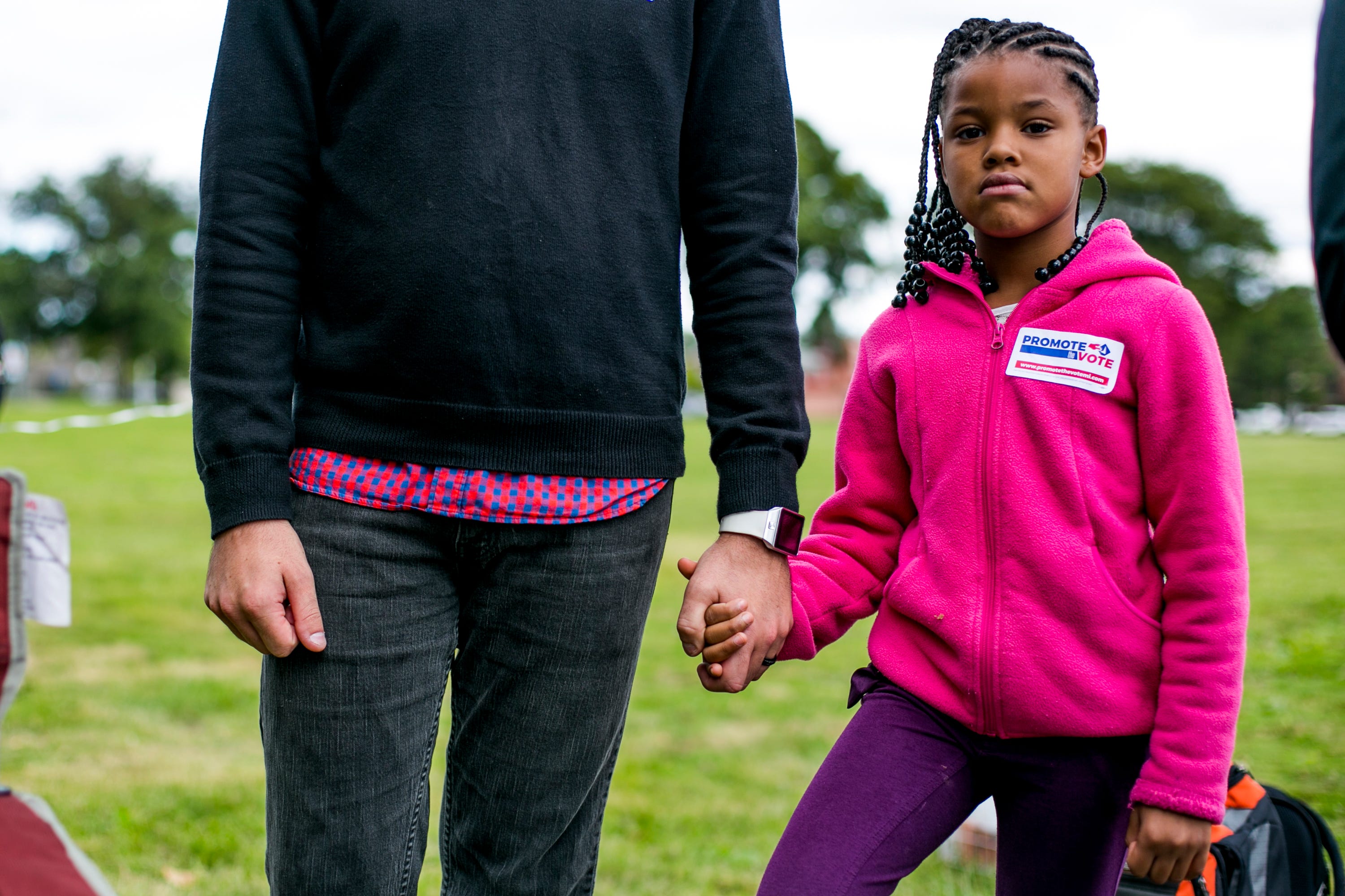 Arleana Jackson, 7, of Livonia holds her step father's hand during the Slut Walk at Palmer Park in Detroit on September 22, 2018.