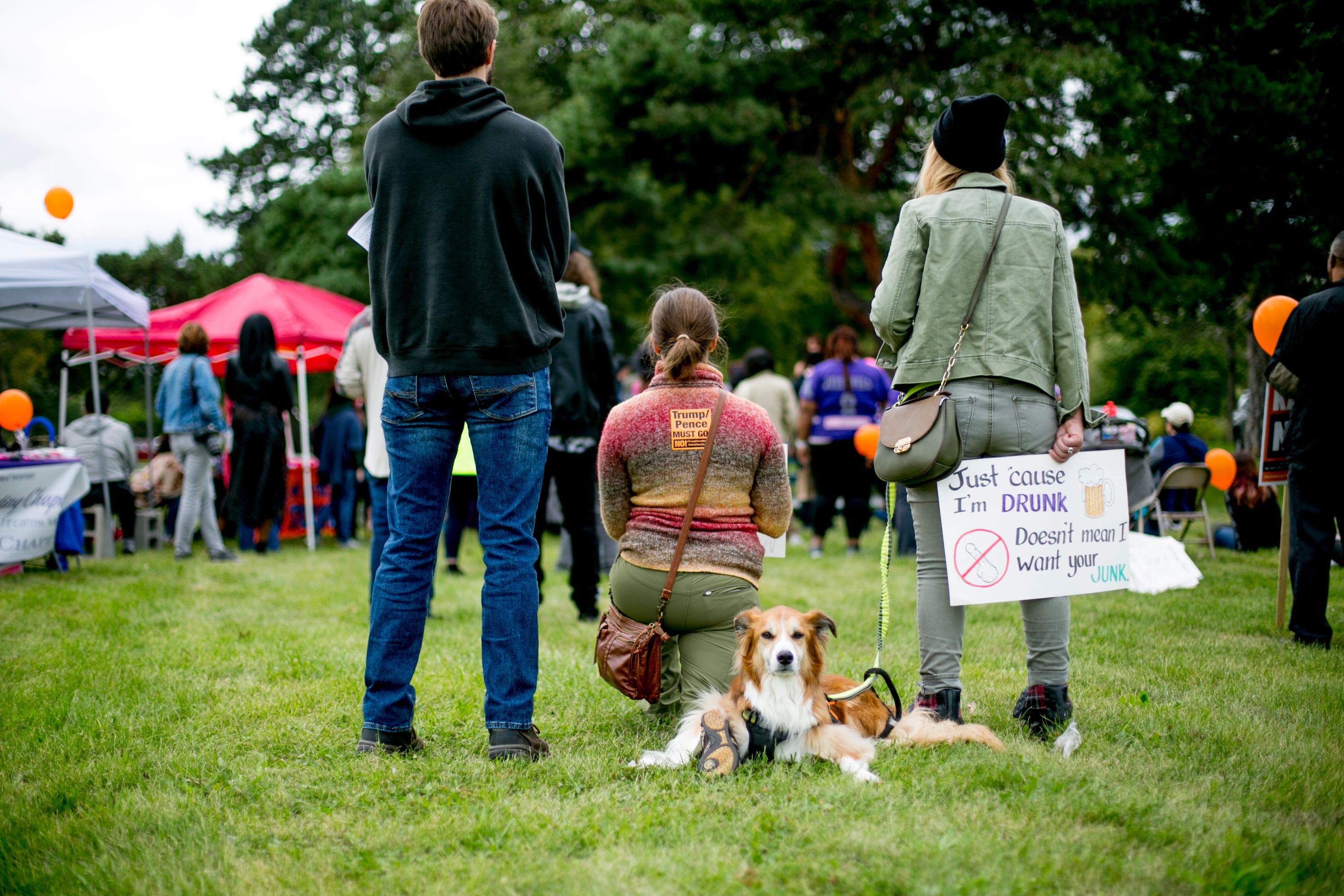 A dog sits in the grass during the Slut Walk at Palmer Park in Detroit.