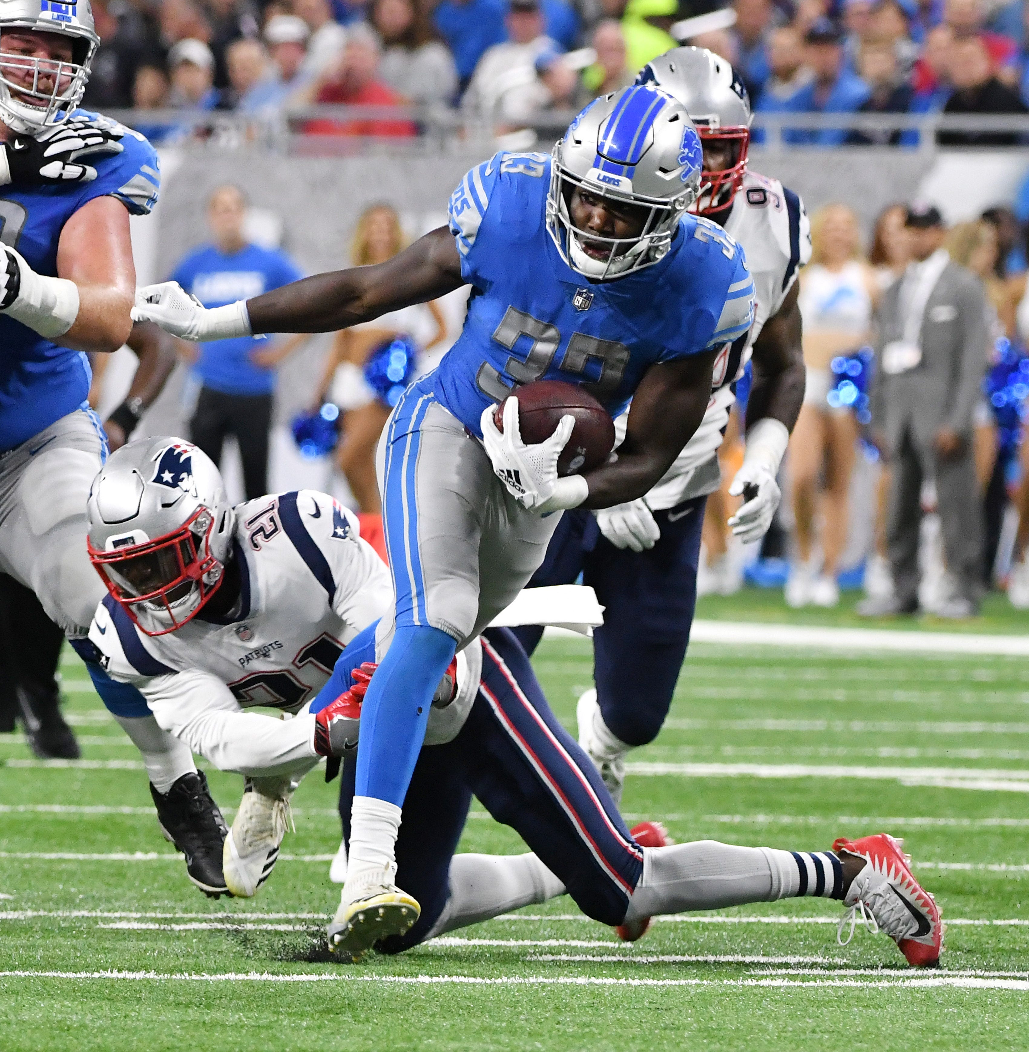 Lions' Kerryon Johnson (33) runs for a first down in the first half.