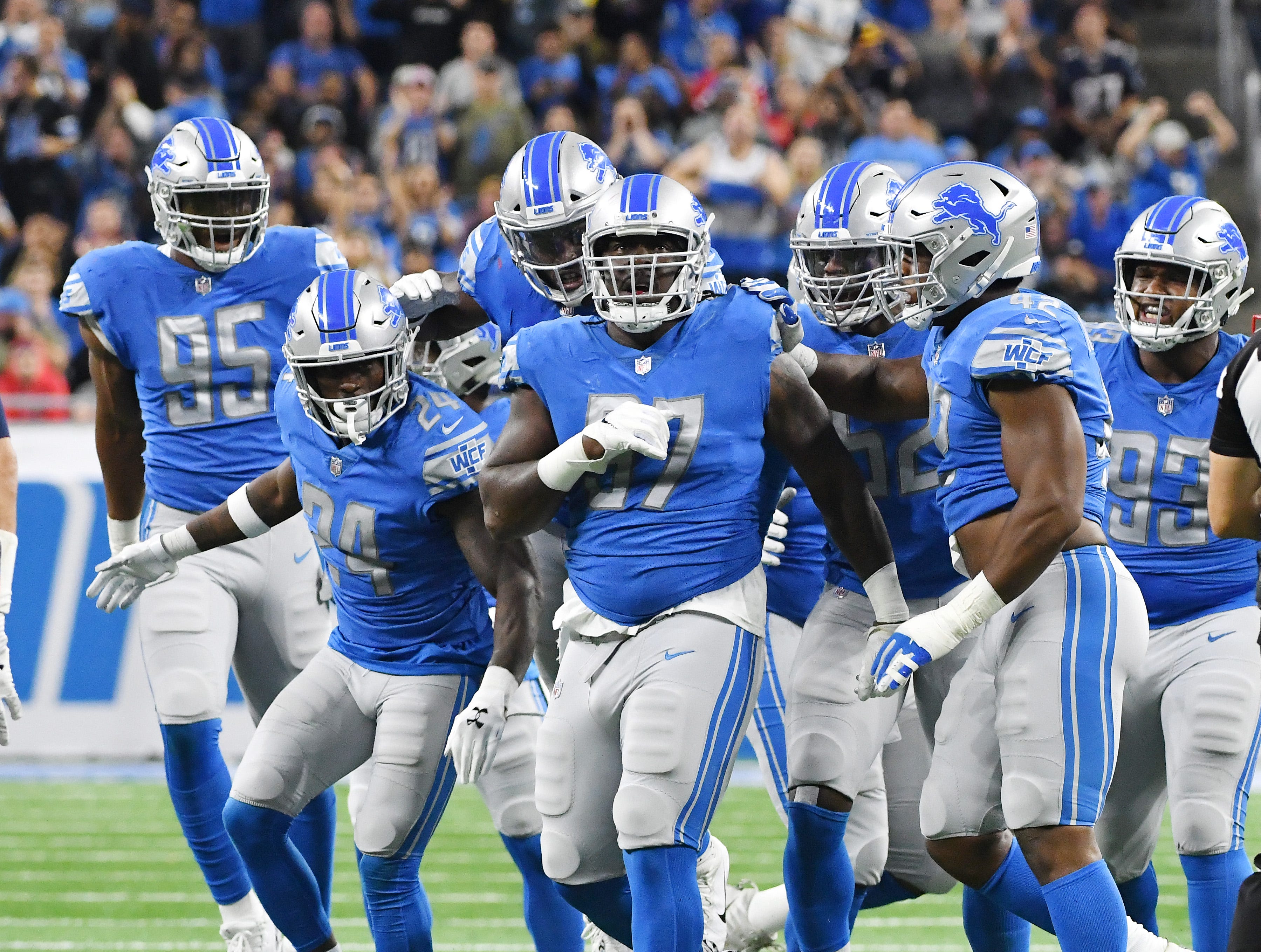 Lions celebrate with teammate Ricky Jean Francois after topping Patriots on third down, forcing New England to punt in the second quarter.