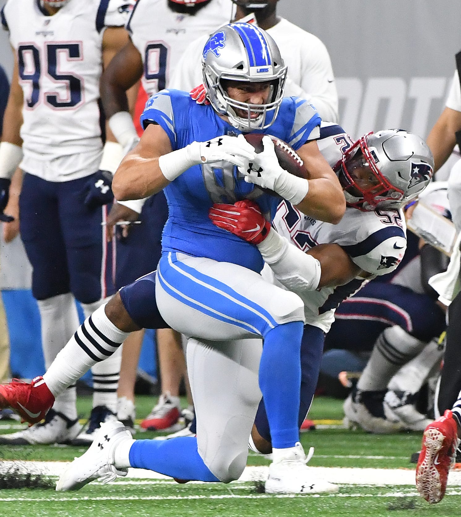 Lions tight end Luke Wilson holds onto a reception with Patriots' Elandon Roberts defending along the sidelines in the first quarter.