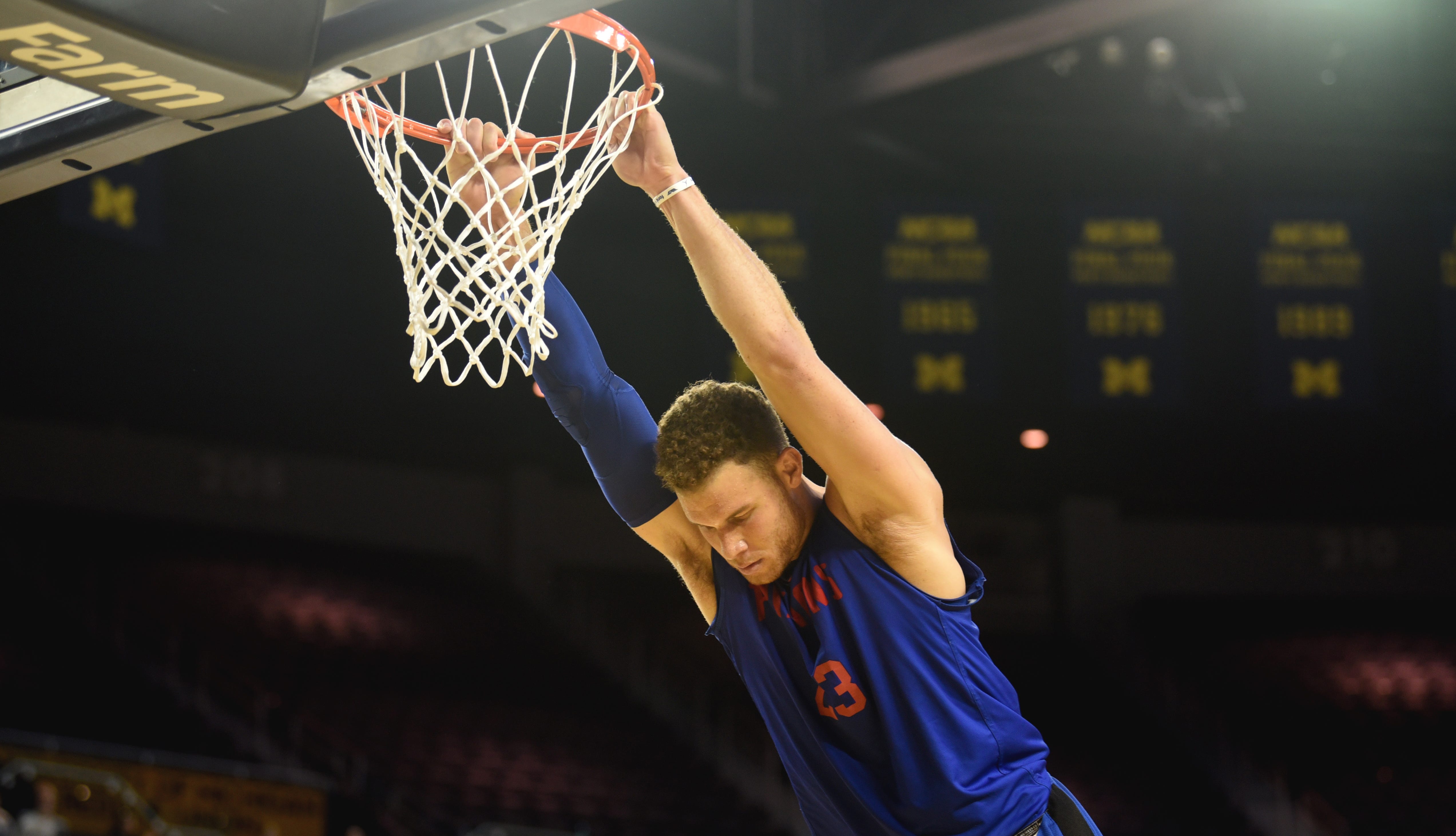 Blake Griffin swings from the rim after making a slam dunk.