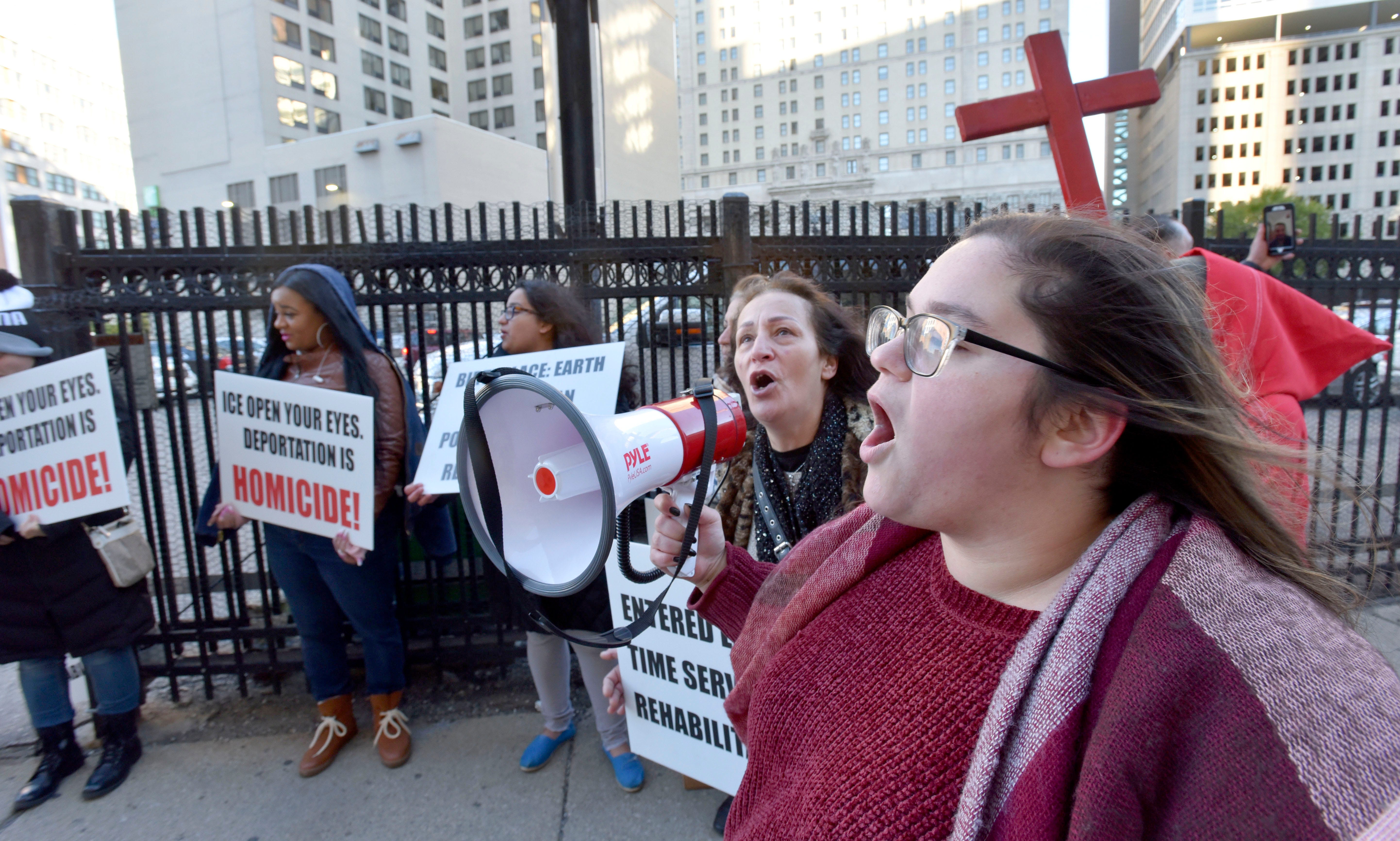 Ashourina Slewo, right, of Madison Heights, holds the bull horn for Linda Markos, of Warren, as they protest in front of Detroit's federal courthouse Wednesday. Slewo's Iraqi-born father, Warda Slewo, was recently released on bond after being detained for nine months. Markos' son, Constantin Markos, has been detained for 1.5 years.