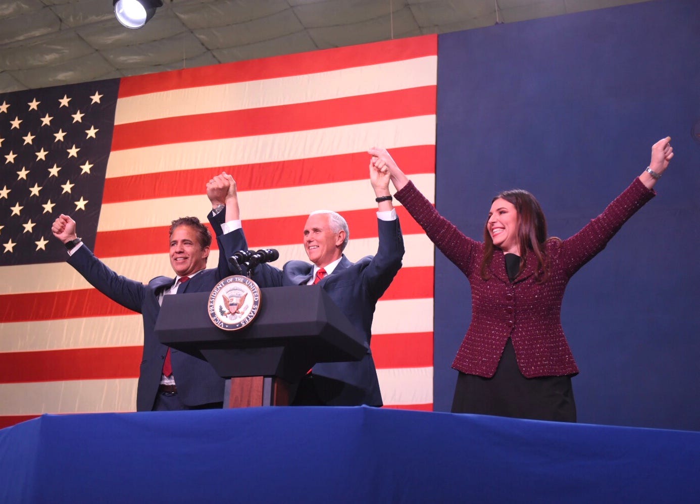 U.S. Rep. Mike Bishop, R-Rochester, Vice President Mike Pence and Lena Epstein, candidate for U.S. Rep. 11th district, join hands during a campaign event Monday at the Oakland County airport in Waterford.