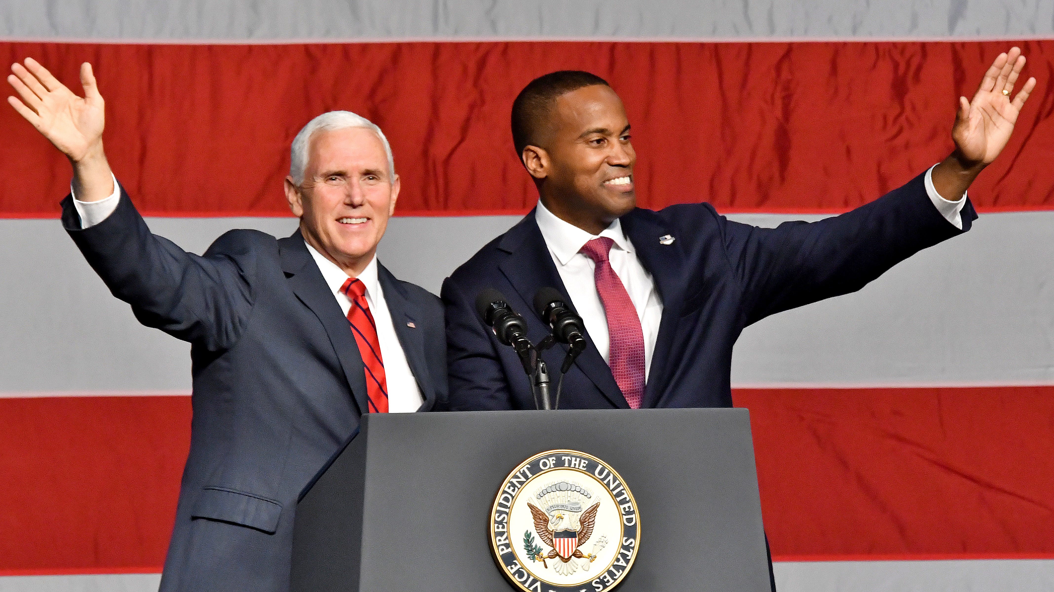 John James and  Vice President Mike Pence wave to the crowd.