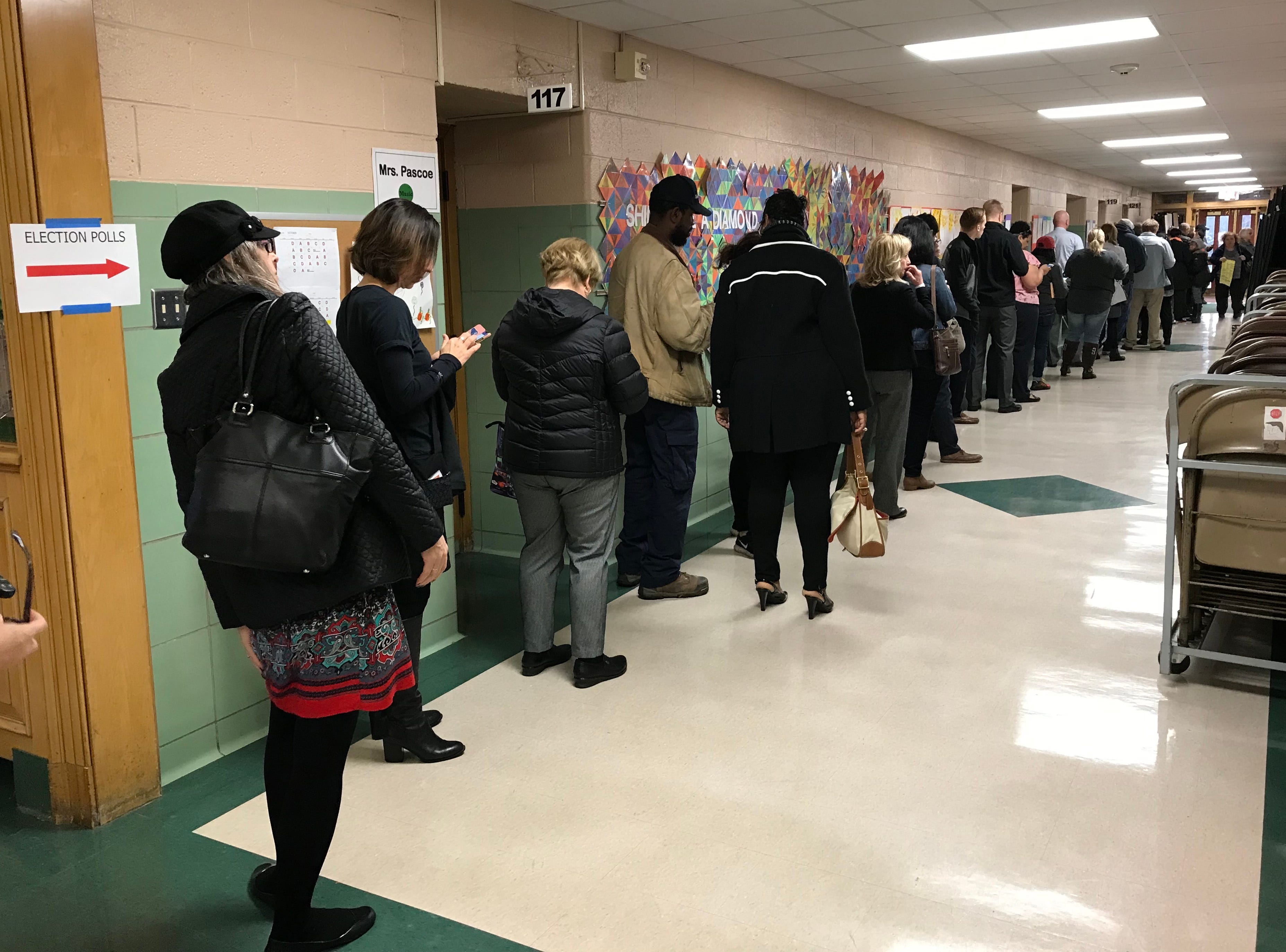 A line of voters wait in the hallway outside the gymnasium at Monteith Elementary School to cast their ballots in the midterm election on Tuesday, Nov. 6, 2018 in Grosse Pointe Woods.
