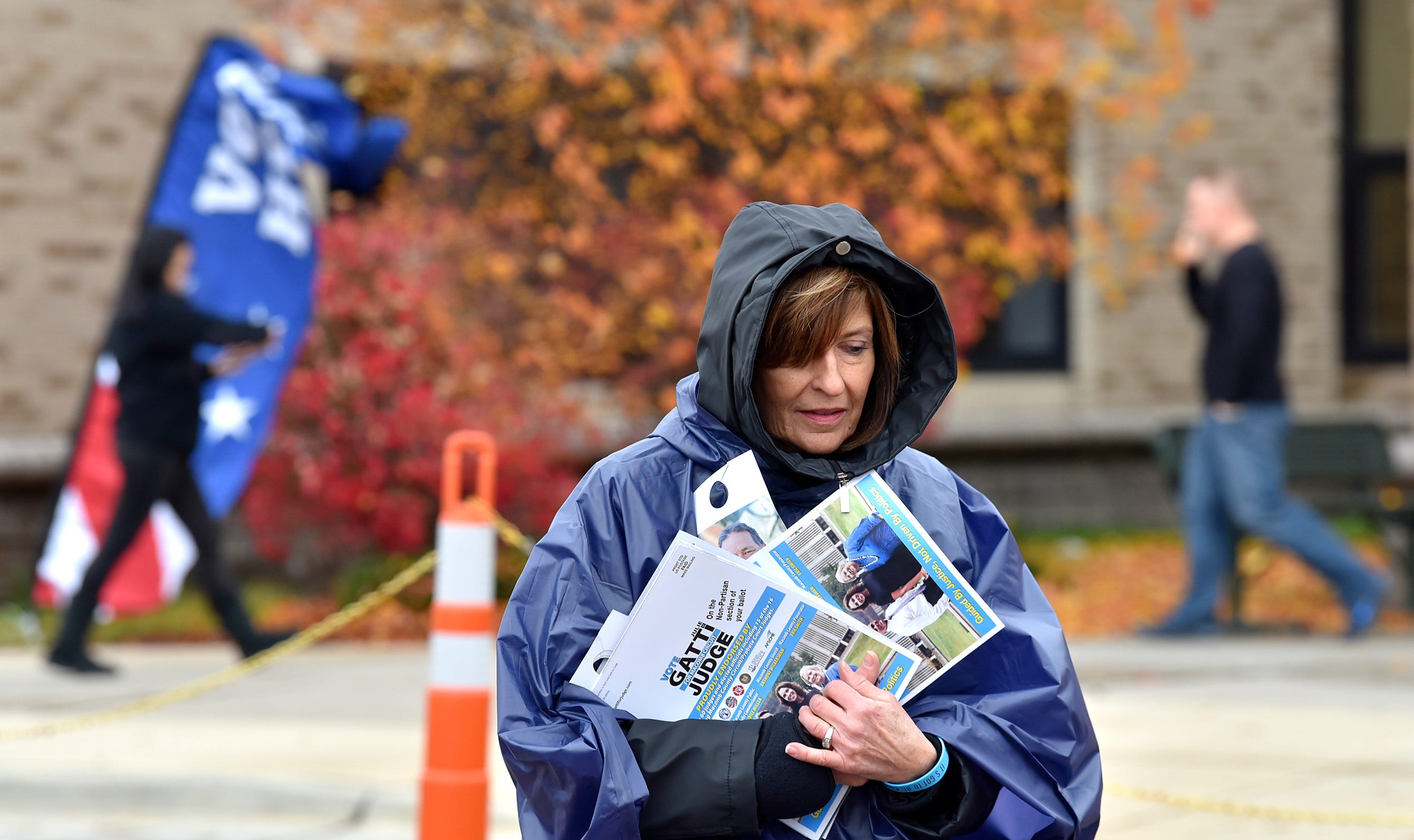 With blustery winds, rain and temperatures in the mid-50s, Linda Anderson of Macomb Township is bundled up to hand out campaign literature outside Ojibwa Elementary School. She is a volunteer for Julie Gatti, a candidate for Macomb County Circuit Court Judge.