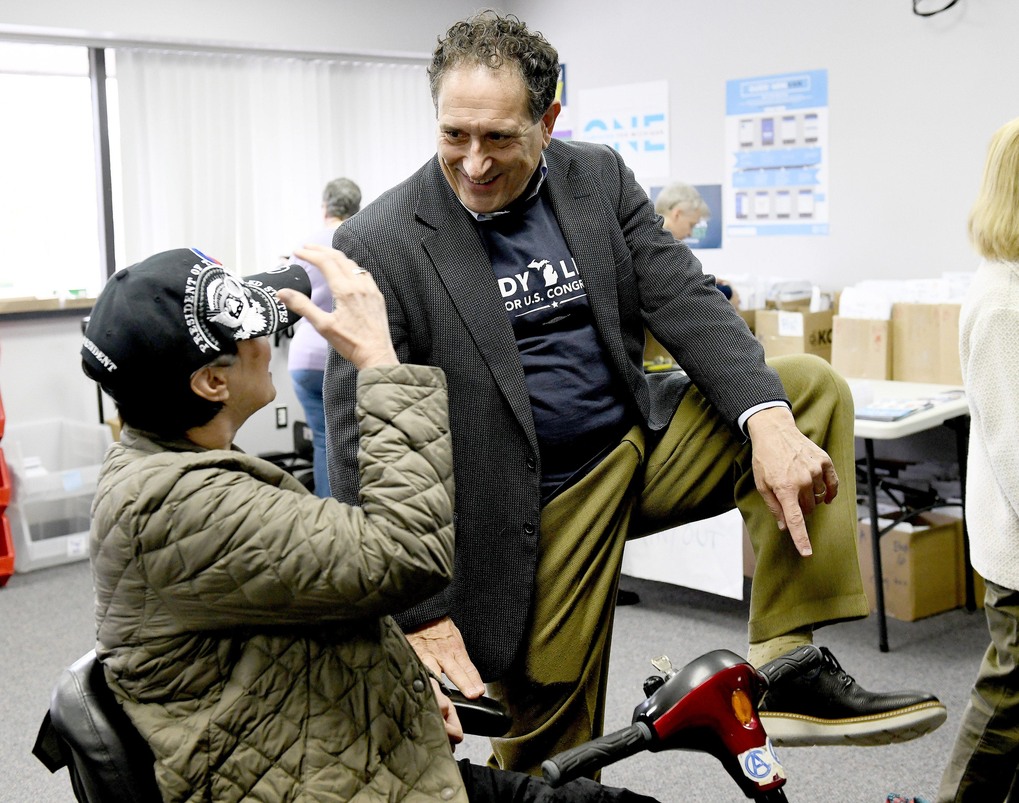 Democratic U.S. Congressional candidate in the 9th District Andy Levin, right, shows his new walking shoes to supporter Ann Serafin of Ferndale after a rally  in Madison Heights, Monday.