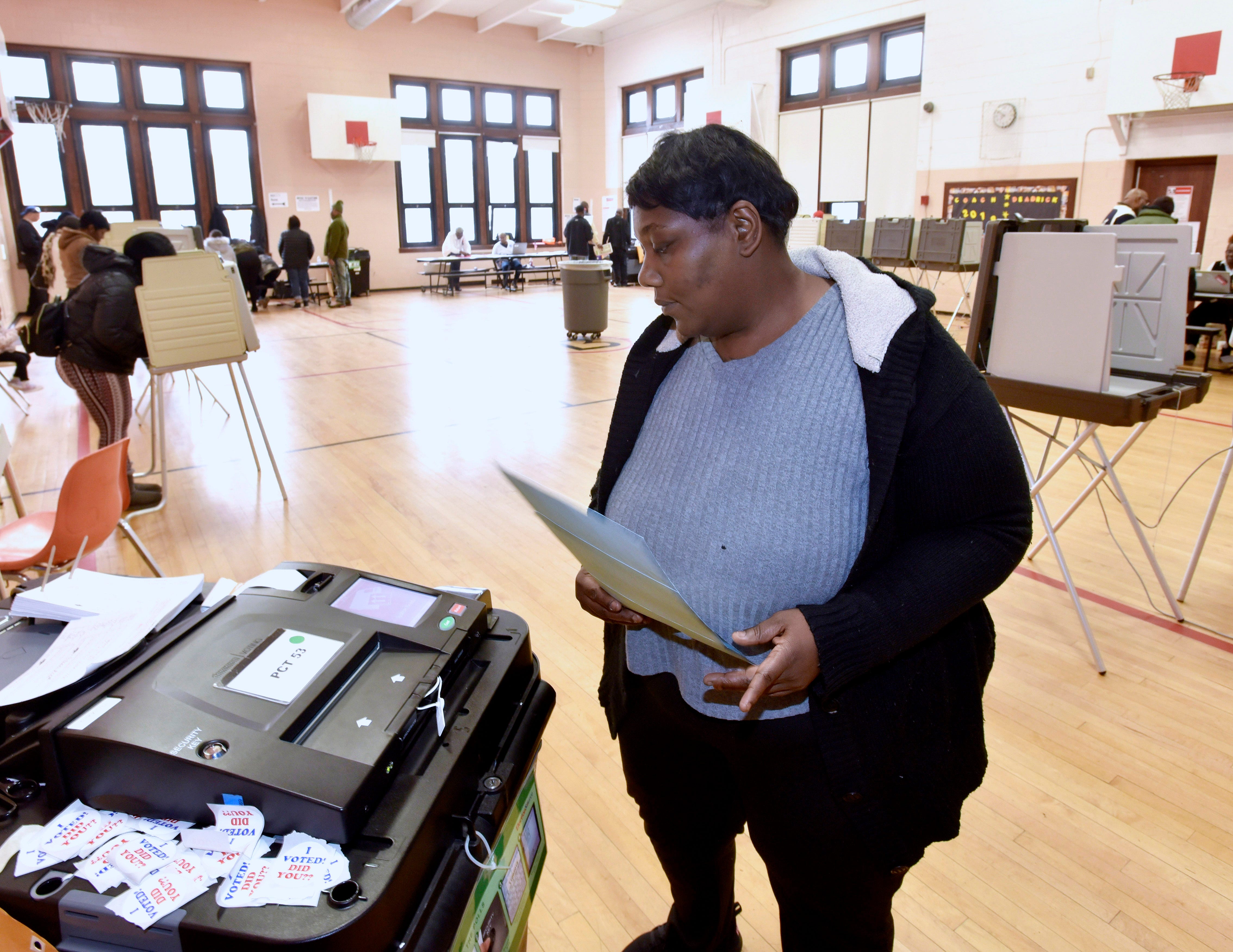 Charmiria Ashford of Detroit casts her ballot in the gym at Brewer Elementary School Tuesday afternoon in Detroit.