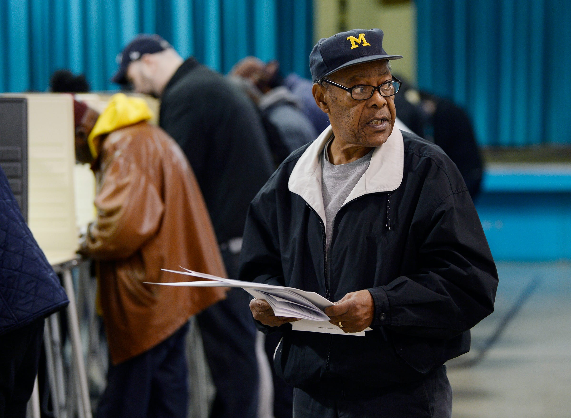 Floyd Hill, 77, of Southfield looks for the scanner to insert his ballot after voting at Adler Elemetary School in Southfield.