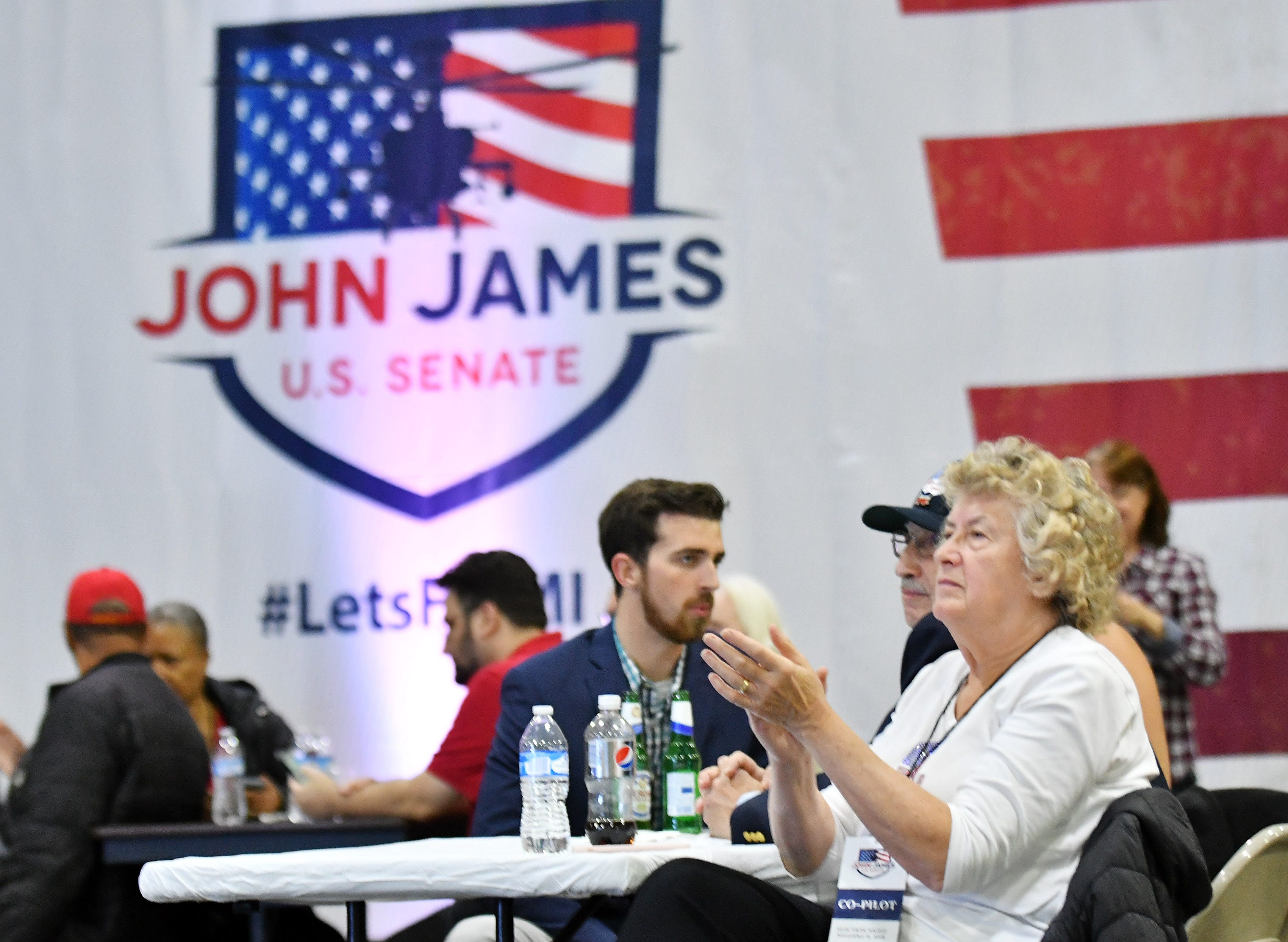 Nancy Corsett of Lexington applauds as early results are shown on television at the election night party for U.S. Senate Republican candidate John James at James Group International in Detroit Tuesday night.