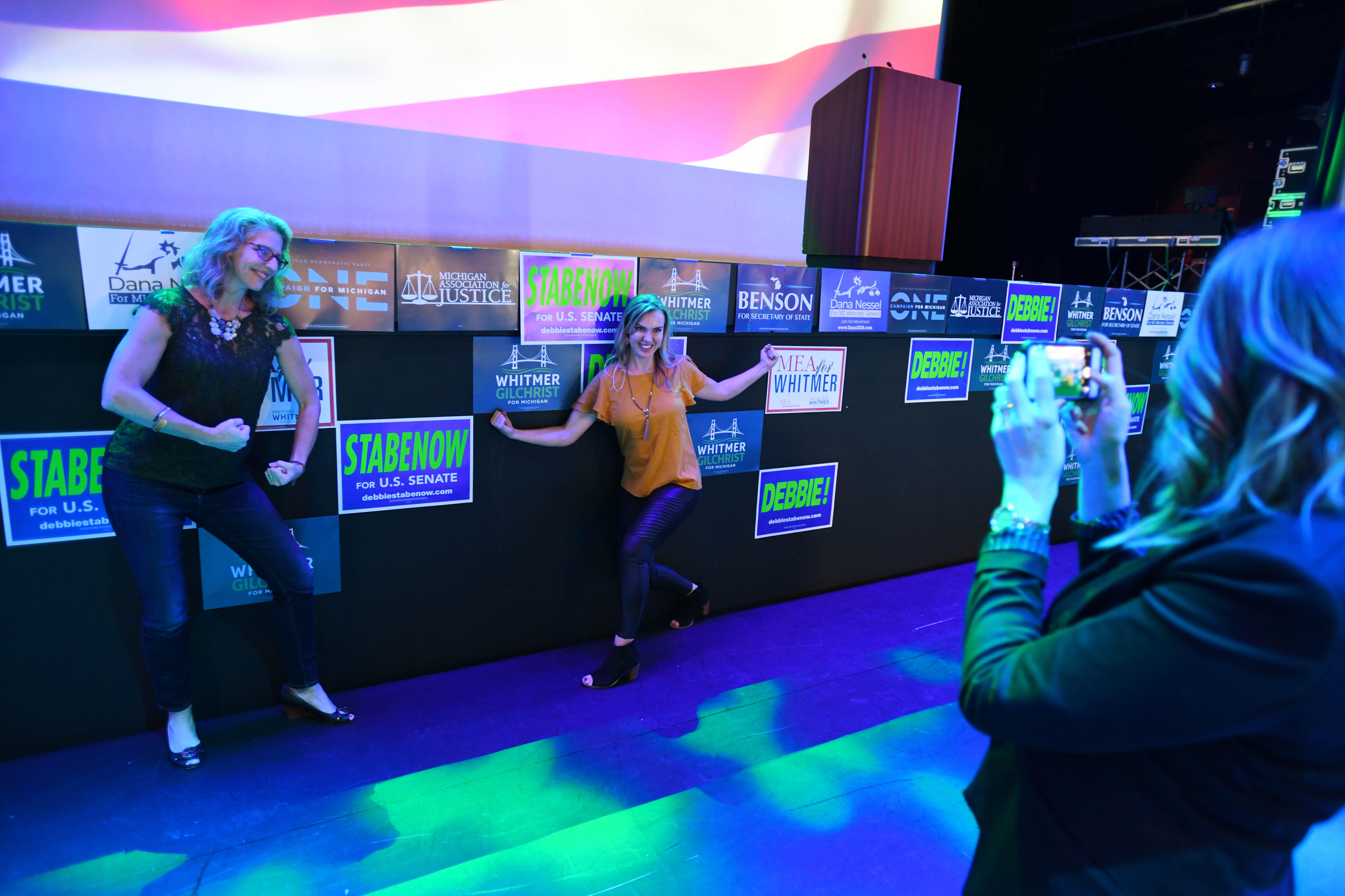 Amy Jonker and Andrea Forsyth have fun posing for a  photo taken by Sara Vroman in front of the stage where the Democrats are hoping Michigan gubernatorial candidate Gretchen Whitmer will announce a victory later Tuesday night.  Democrats gathered at the Sound Board theater in the MotorCity Casino in Detroit.