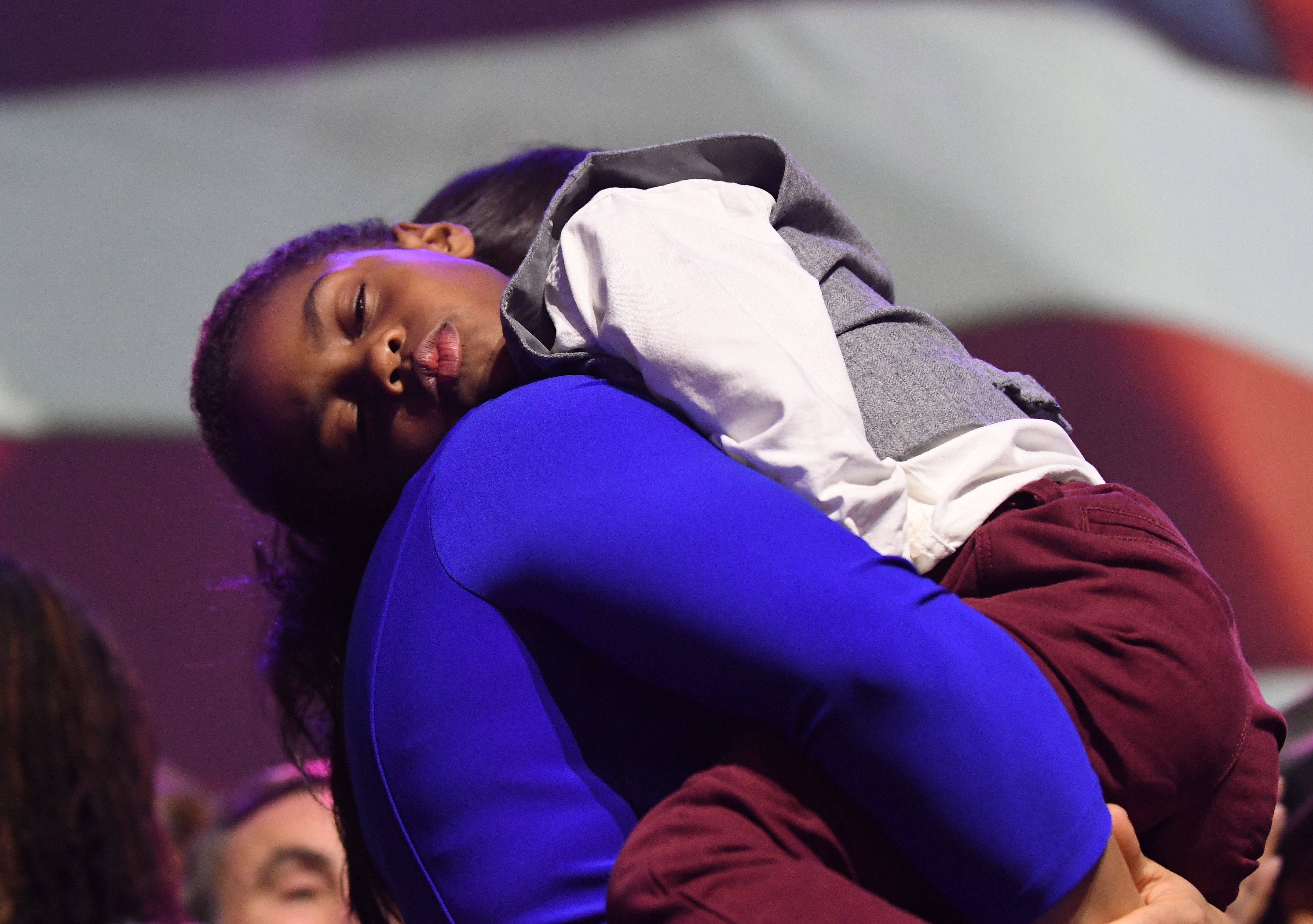Lt. Governor-elect Garlin Gilchrist II's son falls asleep on his wife's shoulder at the  Democratic Party's election night event.