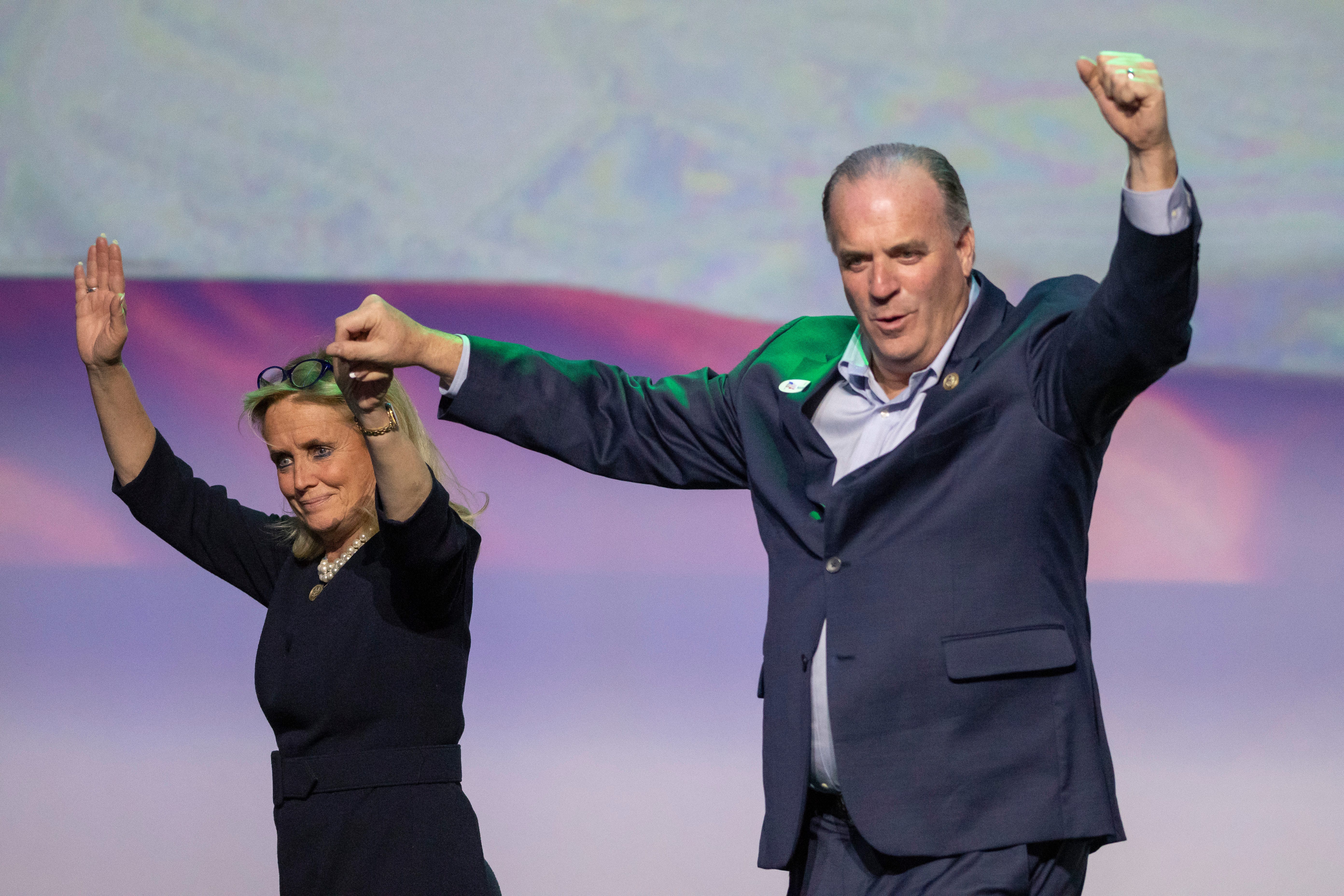 U.S. Rep. Debbie Dingell, left, and U.S. Rep. Dan Kildee join hands after speaking  at the Michigan Democratic Party  election night event at the Sound Board Theater at Motor City Casino in Detroit, November 6, 2018.