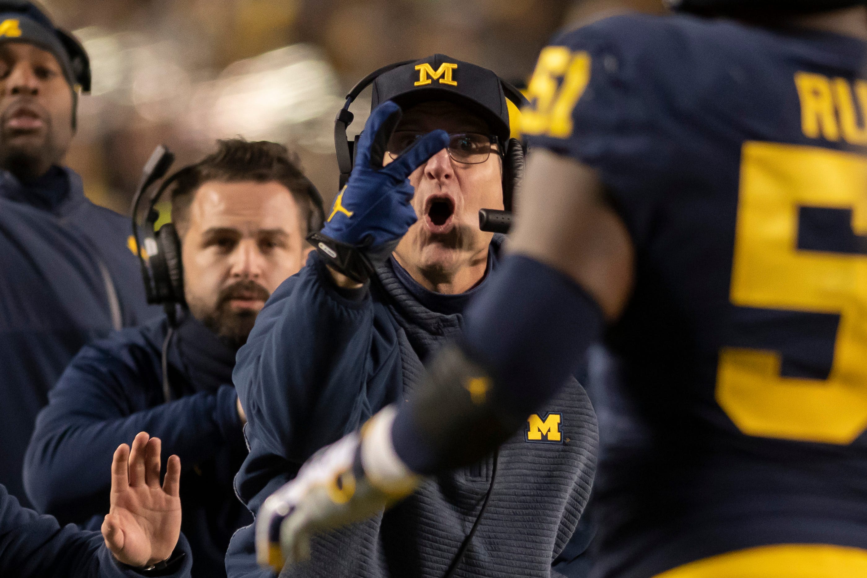 Michigan head coach Jim Harbaugh signals to his players to try for a two-point conversion after a touchdown in the second quarter.