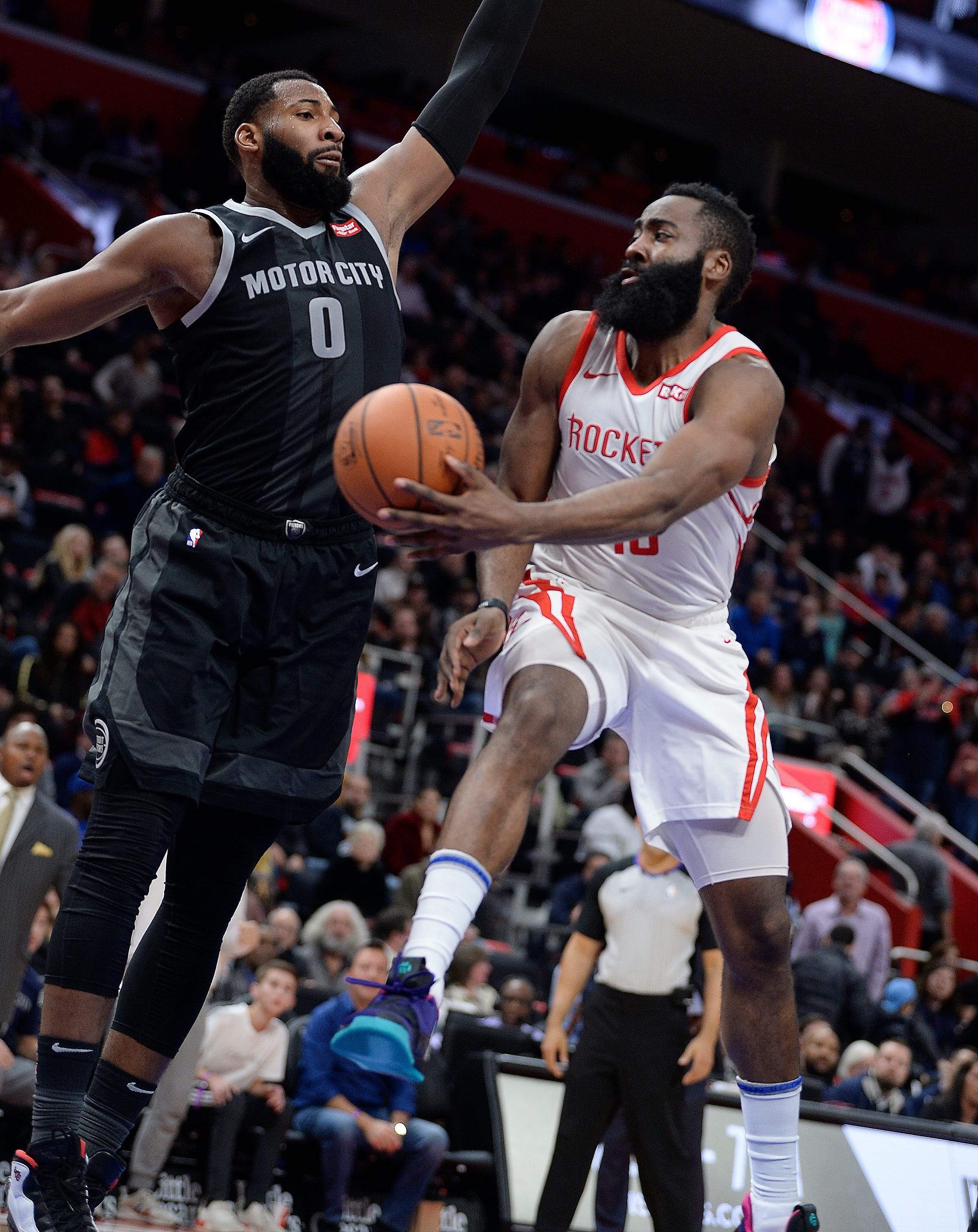 Pistons' Andre Drummond defends Rockets' James Harden in overtime.