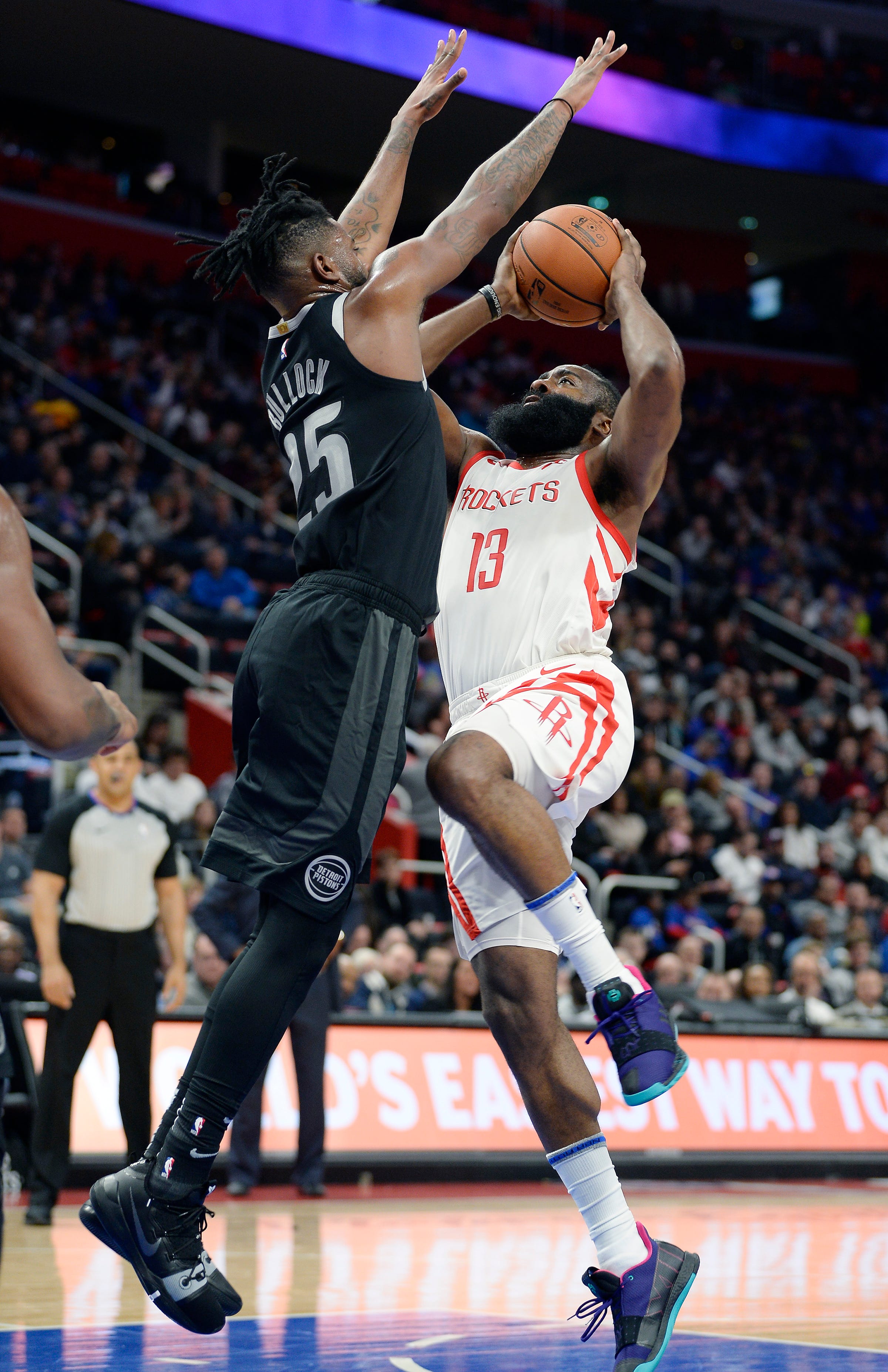 Pistons' Reggie Bullock defends Rockets' James Harden in the third quarter.