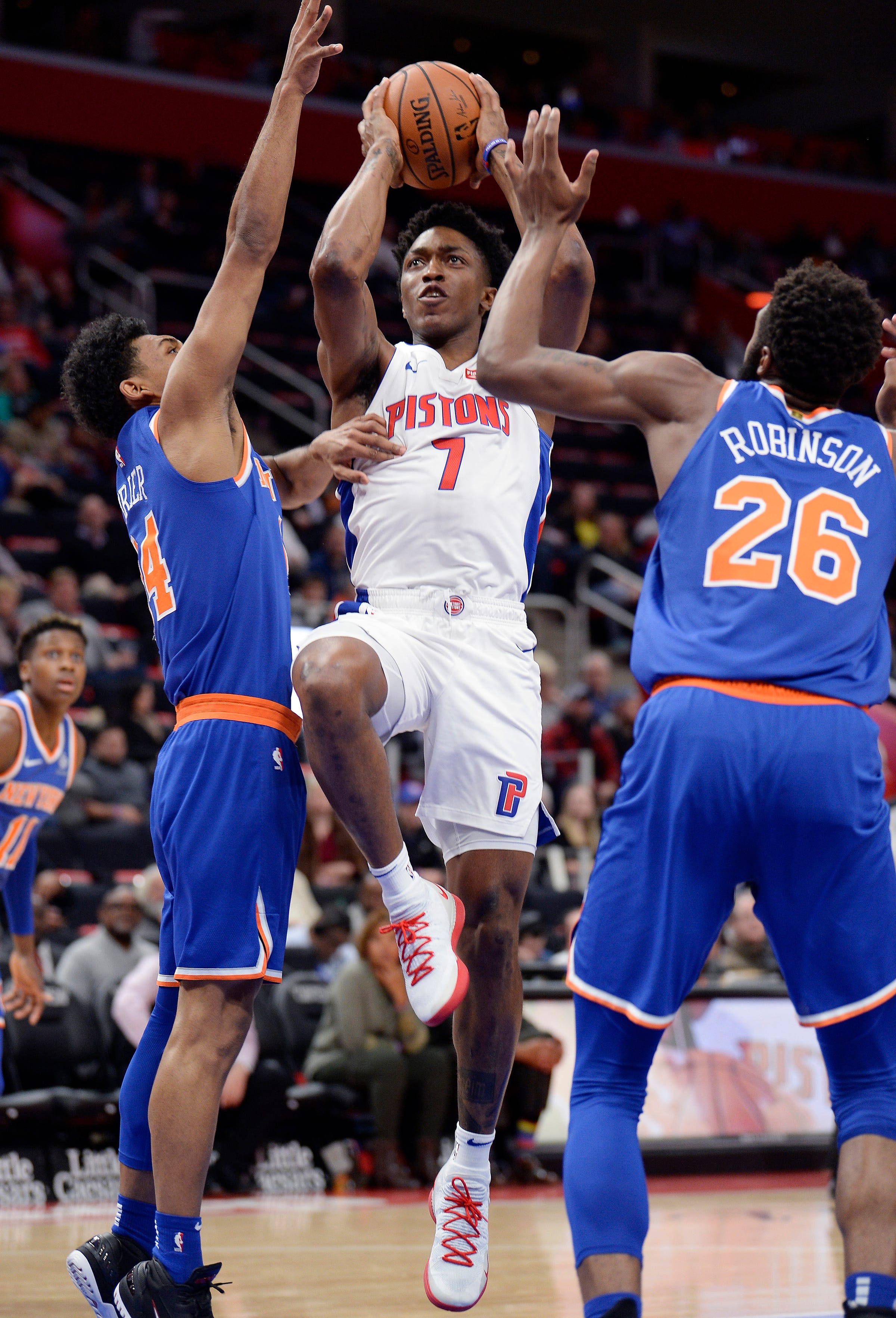 Pistons ' Stanley Johnson shoots over Knicks ' Allonzo Trier, left, and Mitchell Robinson in the second quarter.
