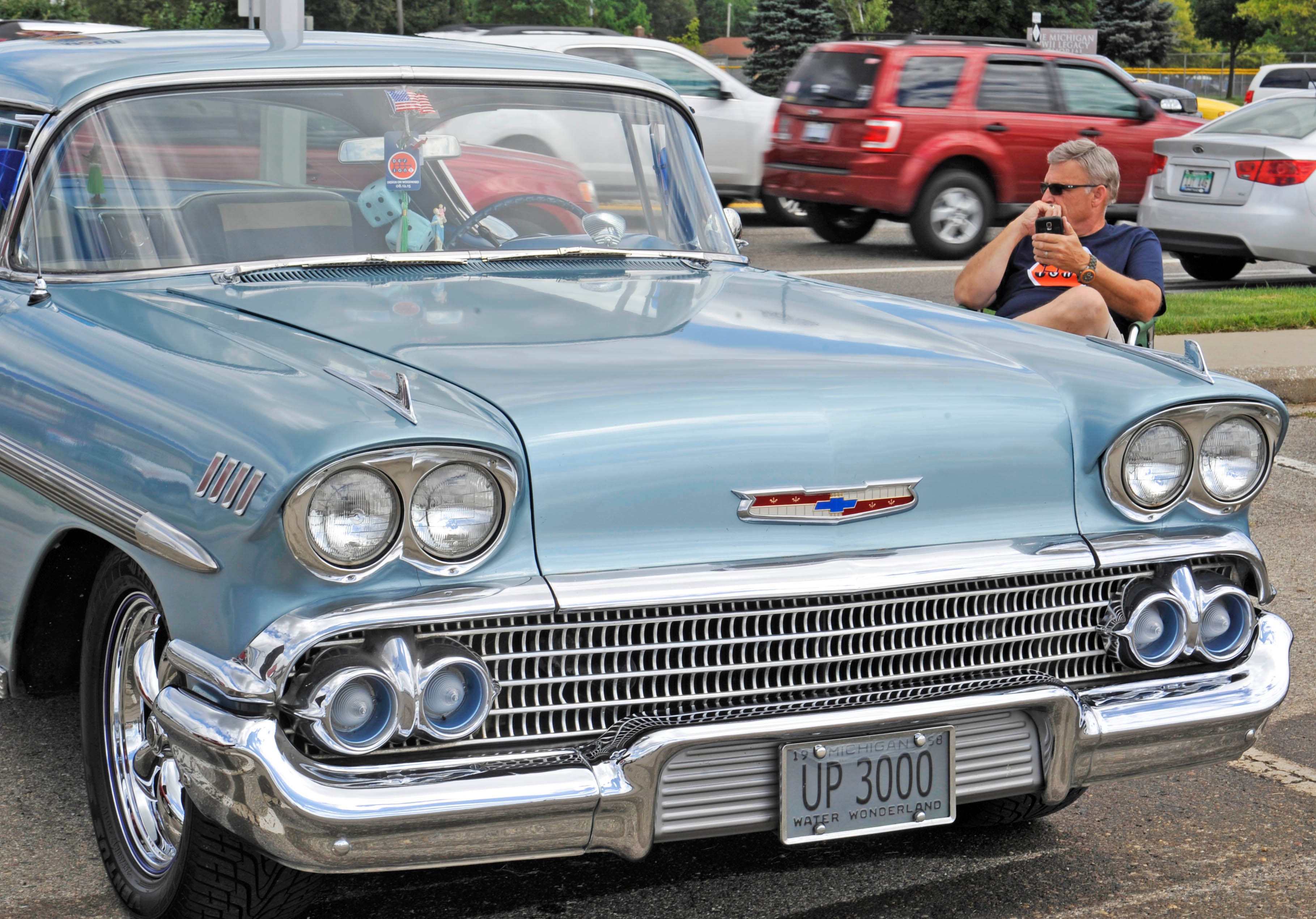 Al Bitell of Livonia sits with his 1958 Chevrolet Impala during a design show as part of the Woodward Dream Cruise at 13 Mile and Woodward in Royal Oak, Aug. 12, 2015.