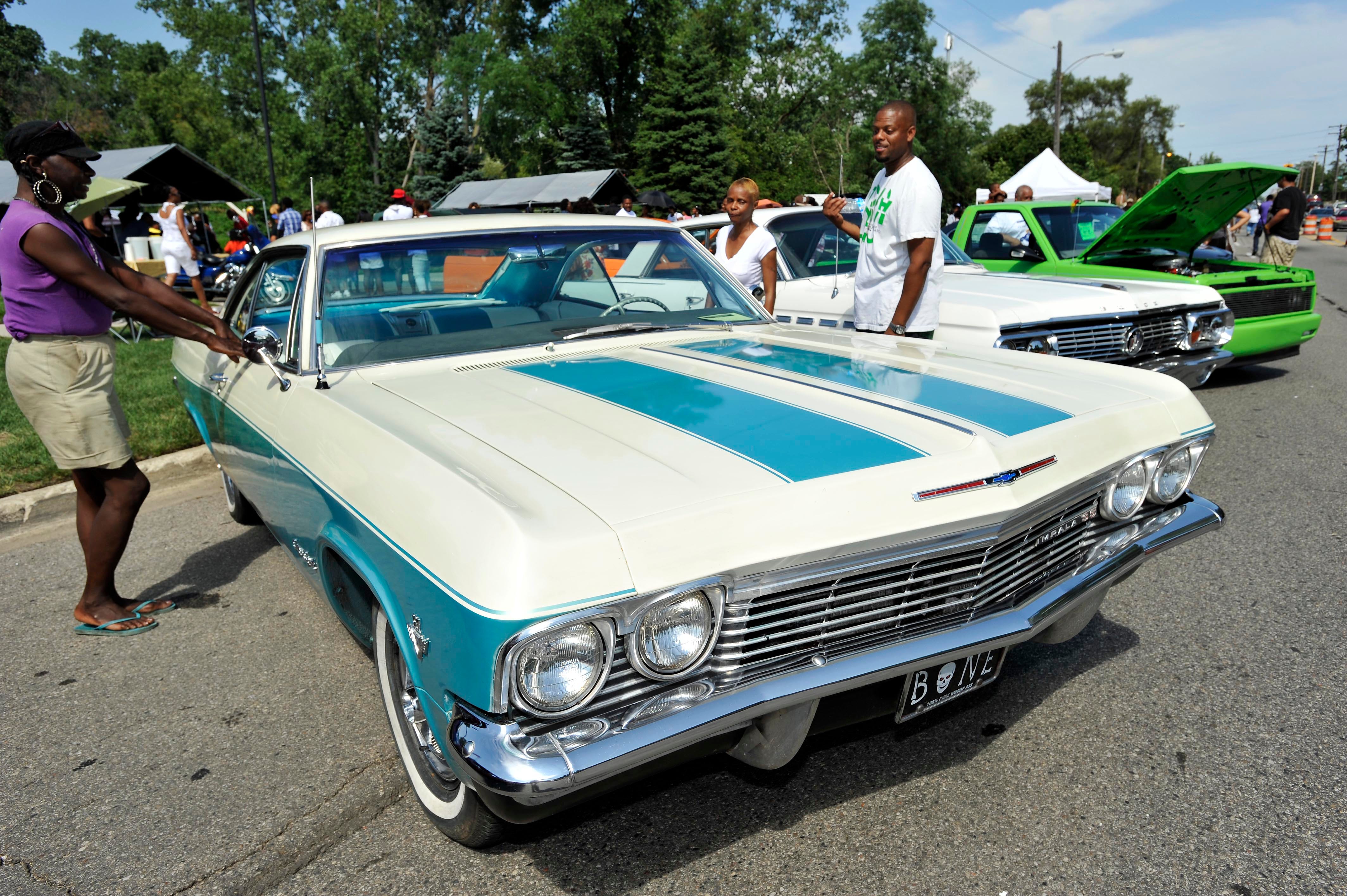 Alonda Hagood, left, and Jackie Good, center, both of Detroit, check out Bernard Hatcher's 1965 Chevrolet Impala on display during the 50th Greater Grace Temple Block Party, Saturday, July 21, 2012.