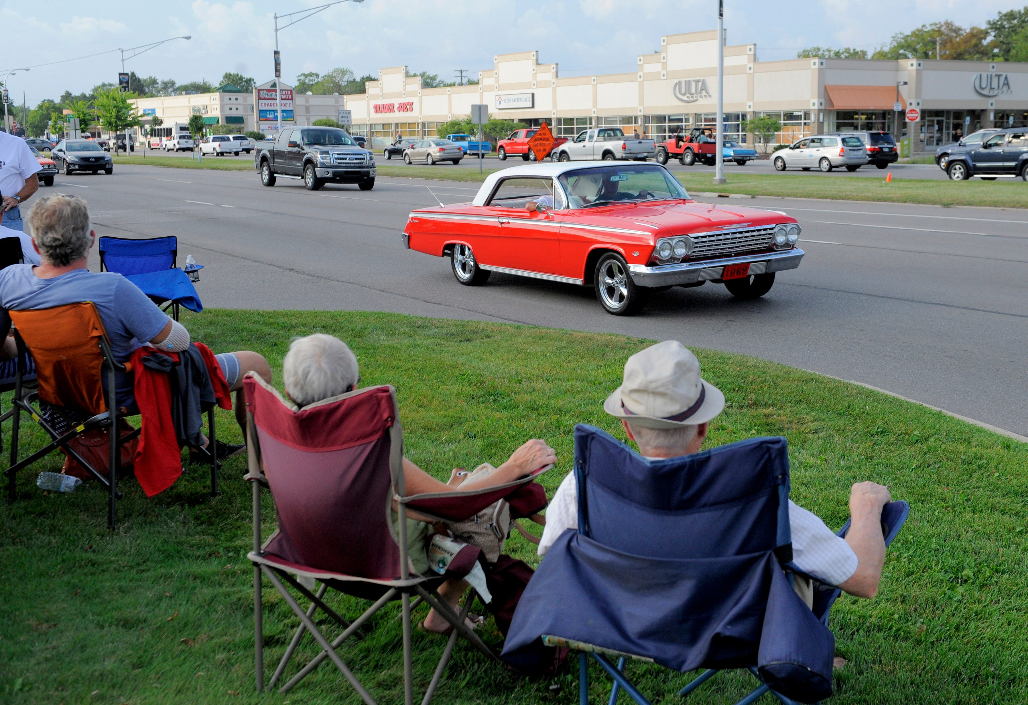 A 1962 Chevrolet Impala passes by several spectators, Friday Aug. 14, 2015, on Woodward near 11 Mile in Royal Oak.