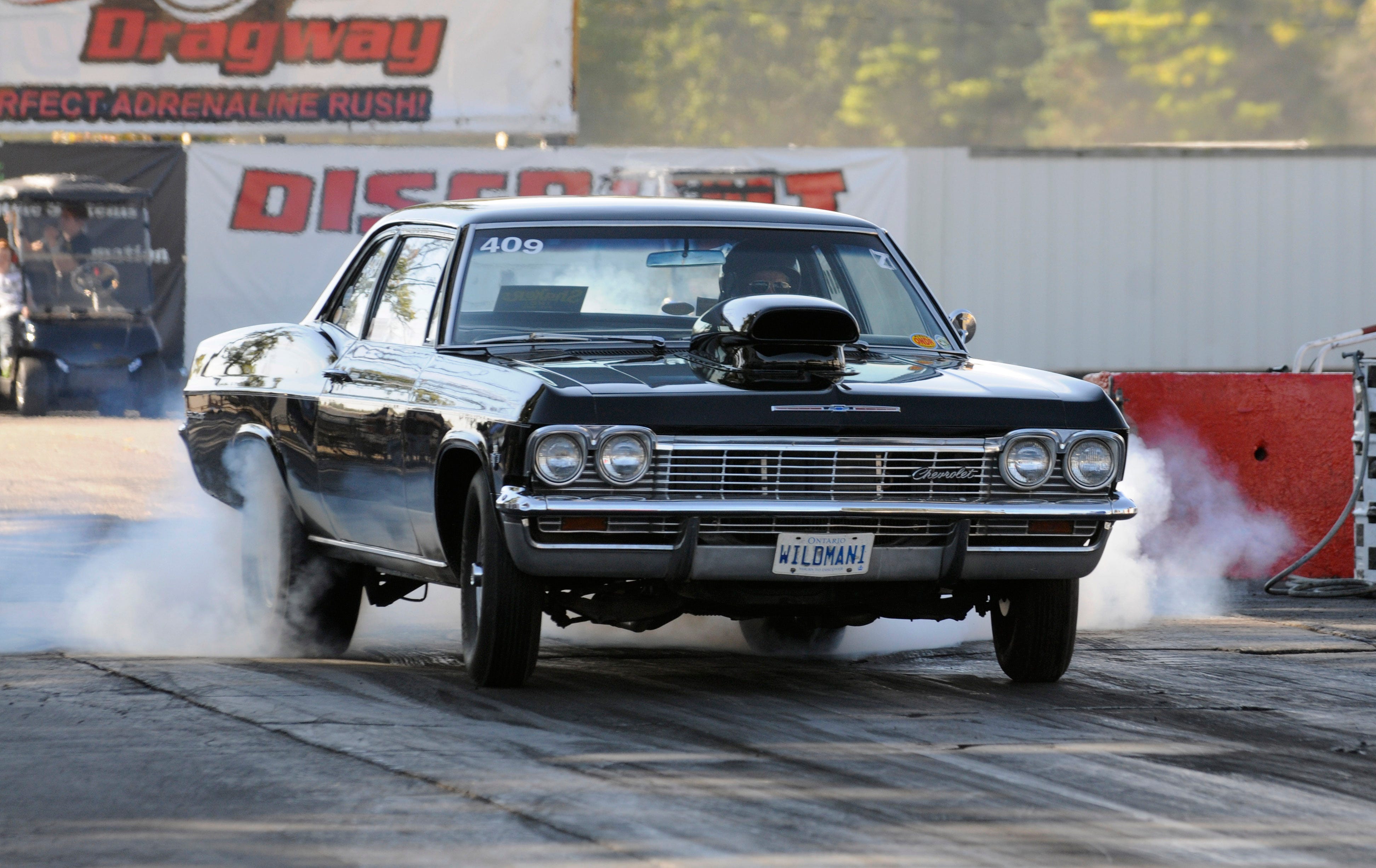 Bob Walker of Windsor performs a burnout in his 1965 Chevrolet Impala with a 409 cubic inch engine, Saturday Sept. 27, 2014, during nostalgia drag racing at Milan Dragway in Milan.