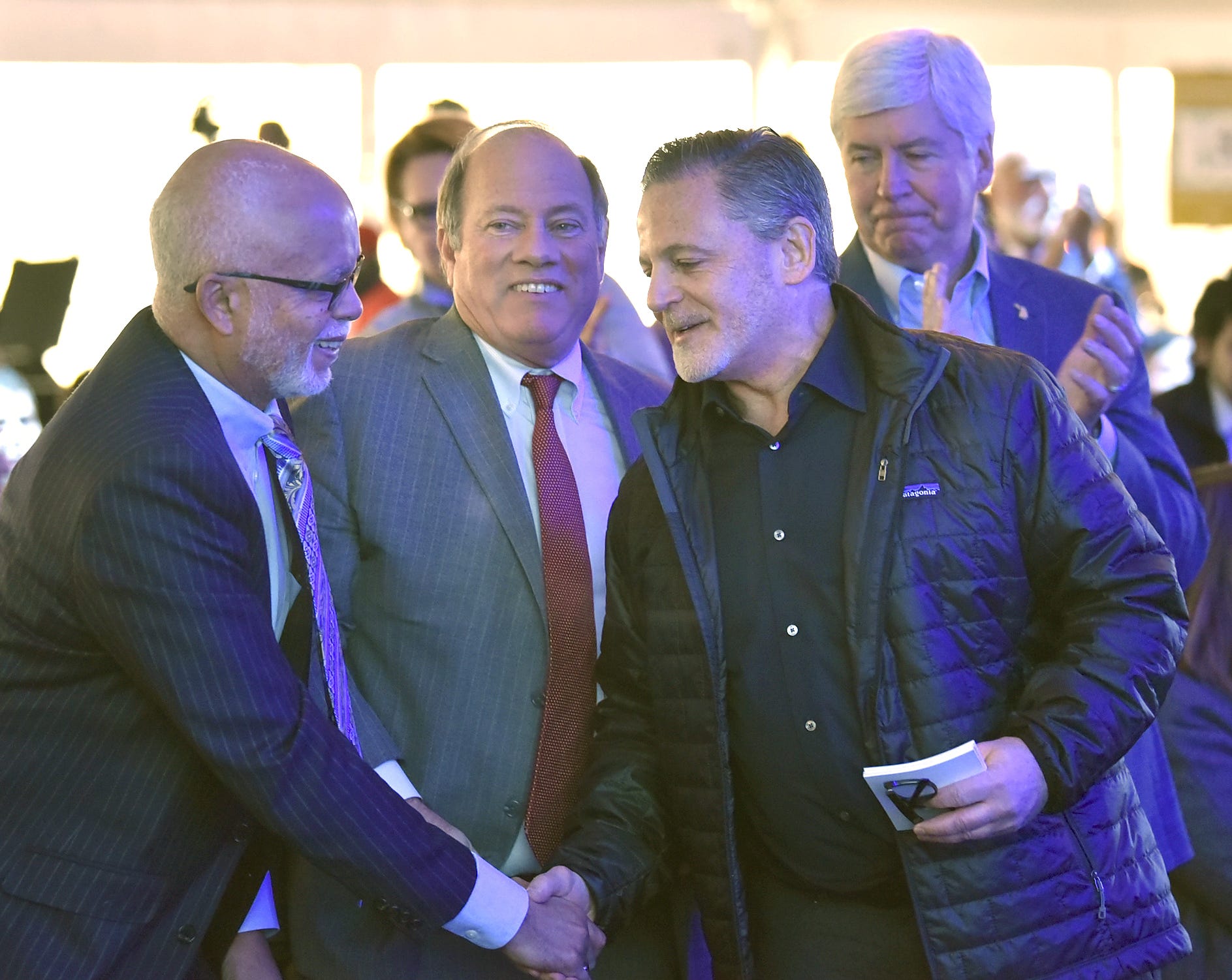 Bedrock Chairman Dan Gilbert, second from right, shakes hands with, left to right, Wayne County Executive Warren Evans, Detroit Mayor Mike Duggan and Michigan Governor Rick Snyder after he speaks.