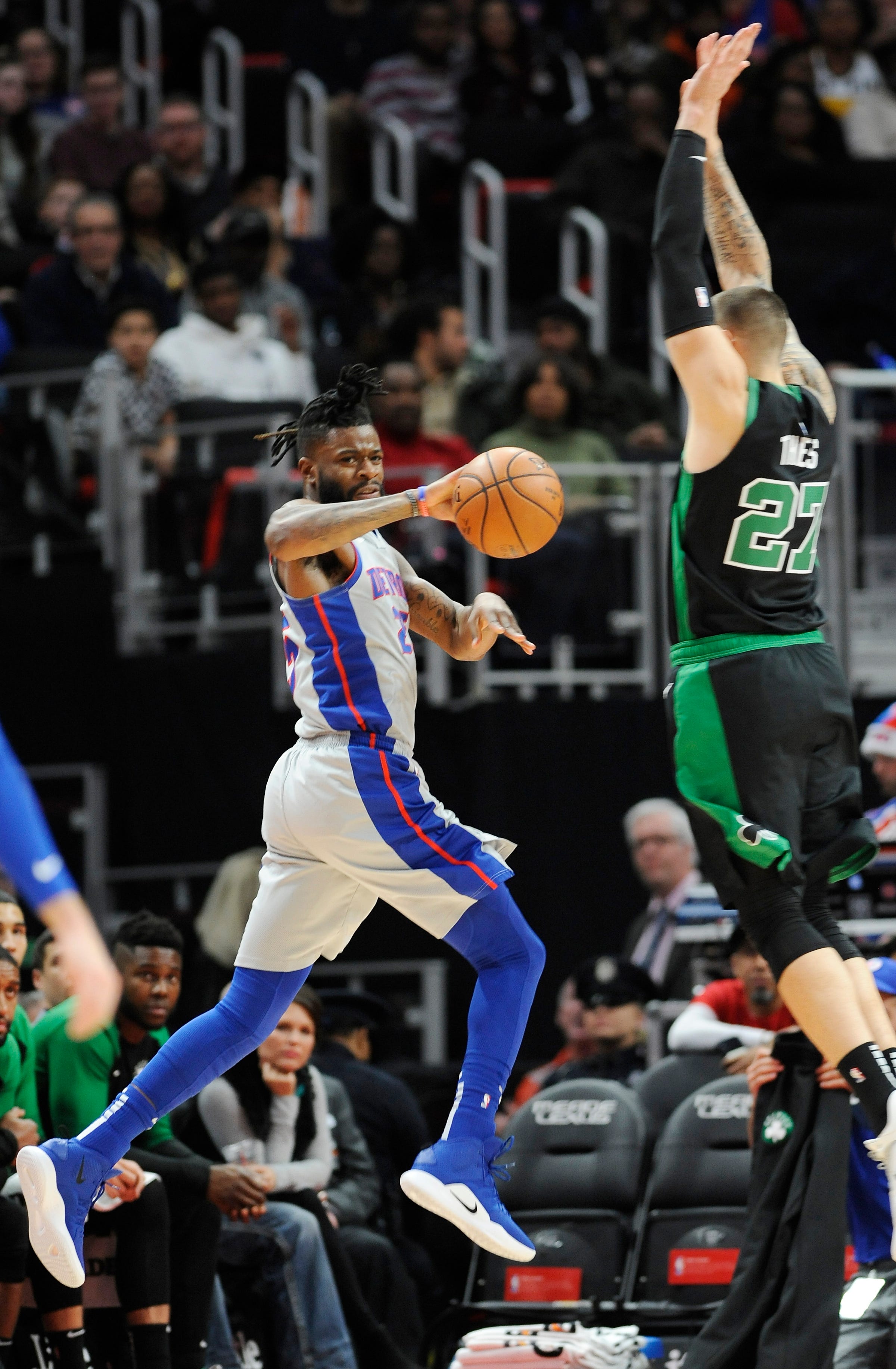 Pistons ' Reggie Bullock makes a pass over the Celtics ' Daniel Theis during the first quarter of an NBA basketball game between the Detroit Pistons and the Boston Celtics at Little Caesars Arena on Saturday, December,15, 2018, in Detroit, Michigan.