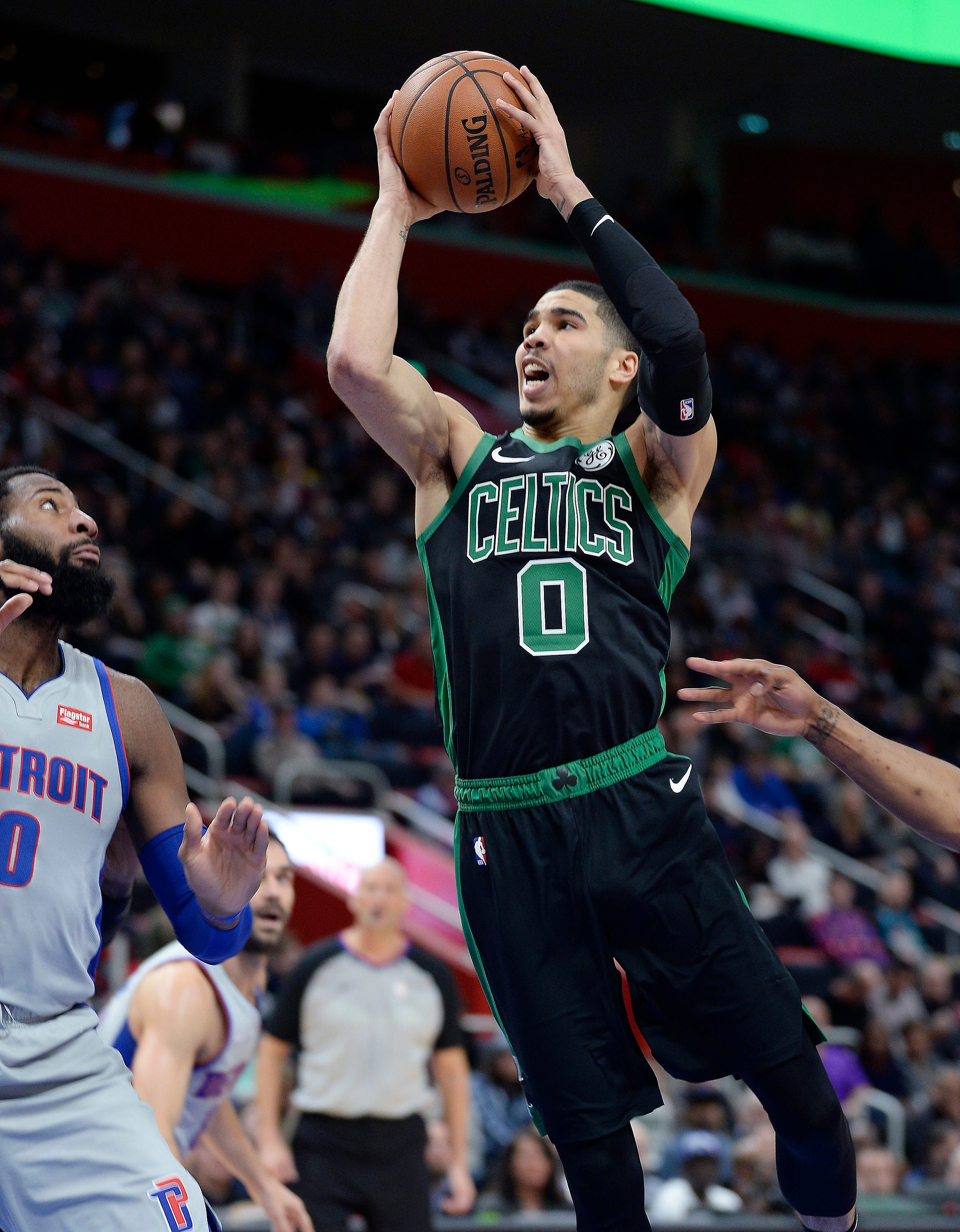 Celtics' Jayson Tatum shoots over Pistons' Andre Drummond in the second quarter.