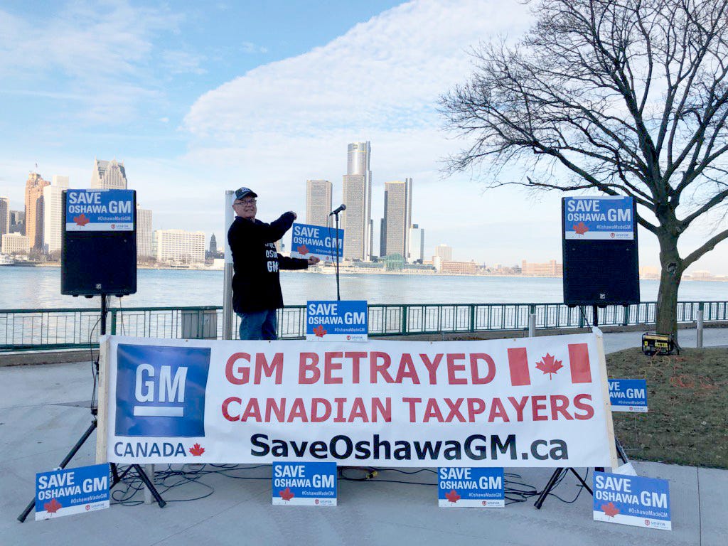 Unifor Canada posted this photo on social media Wednesday showing signs saying 'GM betrayed Canadian Taxpayers' and 'Save Oshawa GM,' positioned across the river from GM's headquarters.