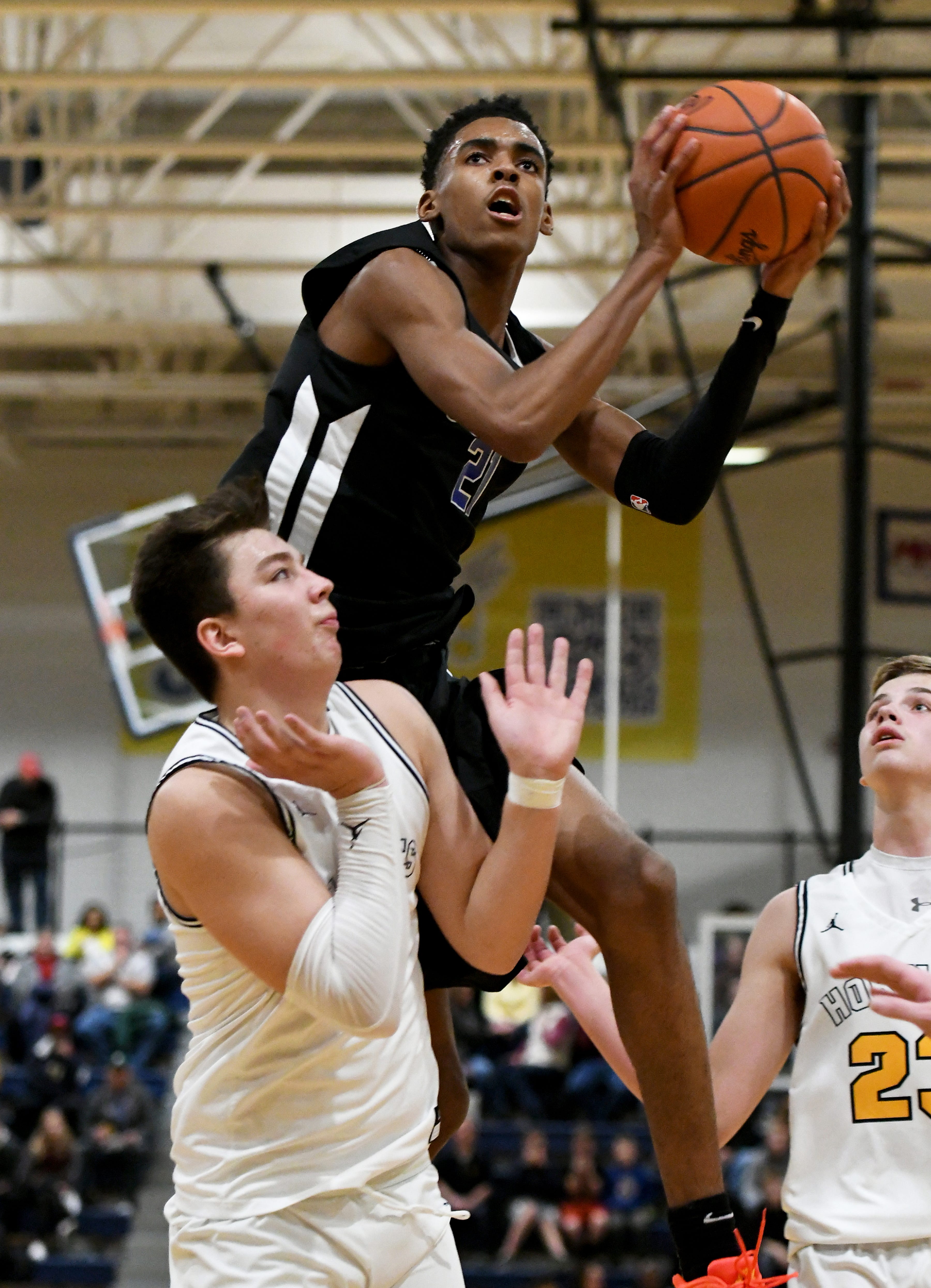 Lincoln High School freshman Emoni Bates drives to the hoop past Saline High School's Logan Evans, bottom, and Griffin Yaklich, right, to pop in two of his game-high 28 points for the Railsplitters in their 70-39 win over Saline, Dec. 7 at Saline High School.