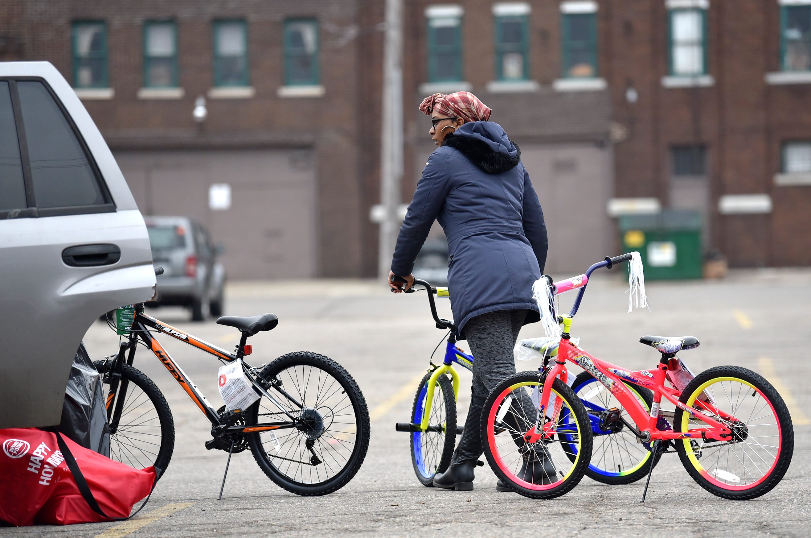 Bianca Robinson of Detroit positions bicycles to be loaded into her vehicle after she and her husband, Juan Bell (not pictured), shop for their four kids.