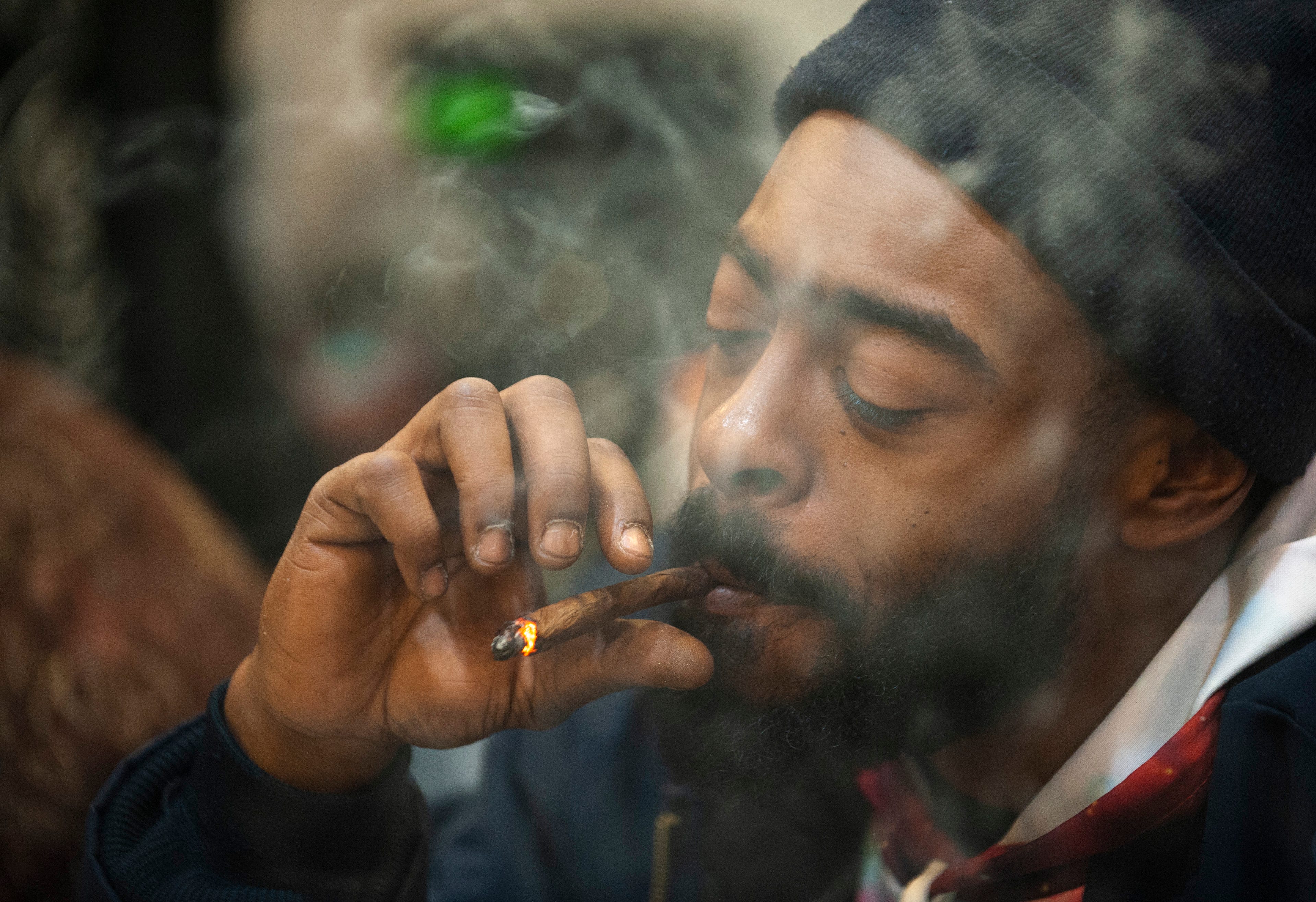 Corey Faison of Inkster puffs on a blunt, marijuana rolled up in a cigar wrap, during "The Art of Cannabis" event at the Cannabis Counsel in Detroit.