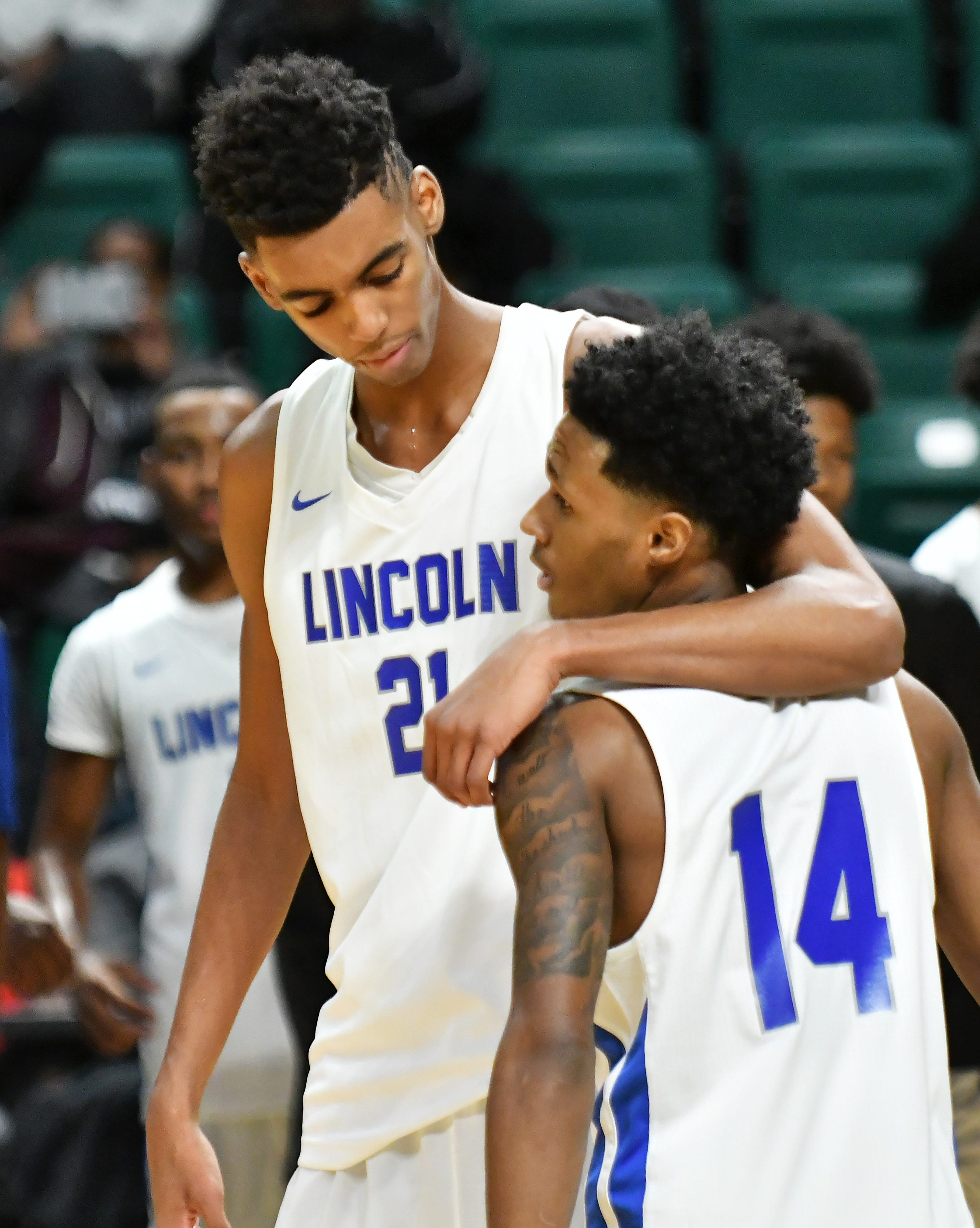Lincoln's Emoni Bates (21) puts his arm around teammate Jalen Fisher during a game against Ann Arbor Huron High School at the EMU Convocation Center.