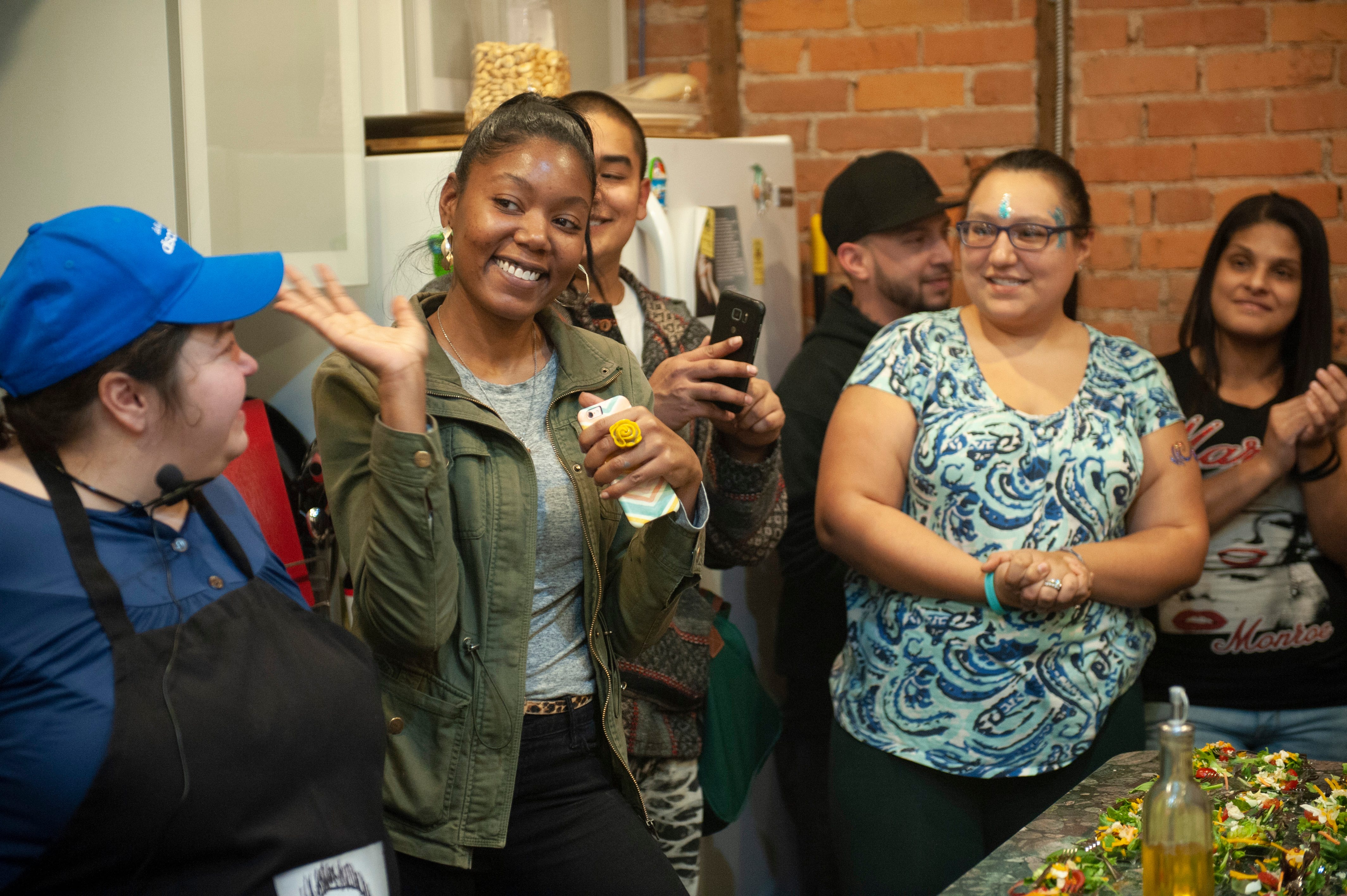 Cannabis entrepreneur Adrienne Benson of AB Blooms in Ypsilanti waves to party guests as she is introduced at the beginning of "The Art of Cannabis" tasting and art exhibition.