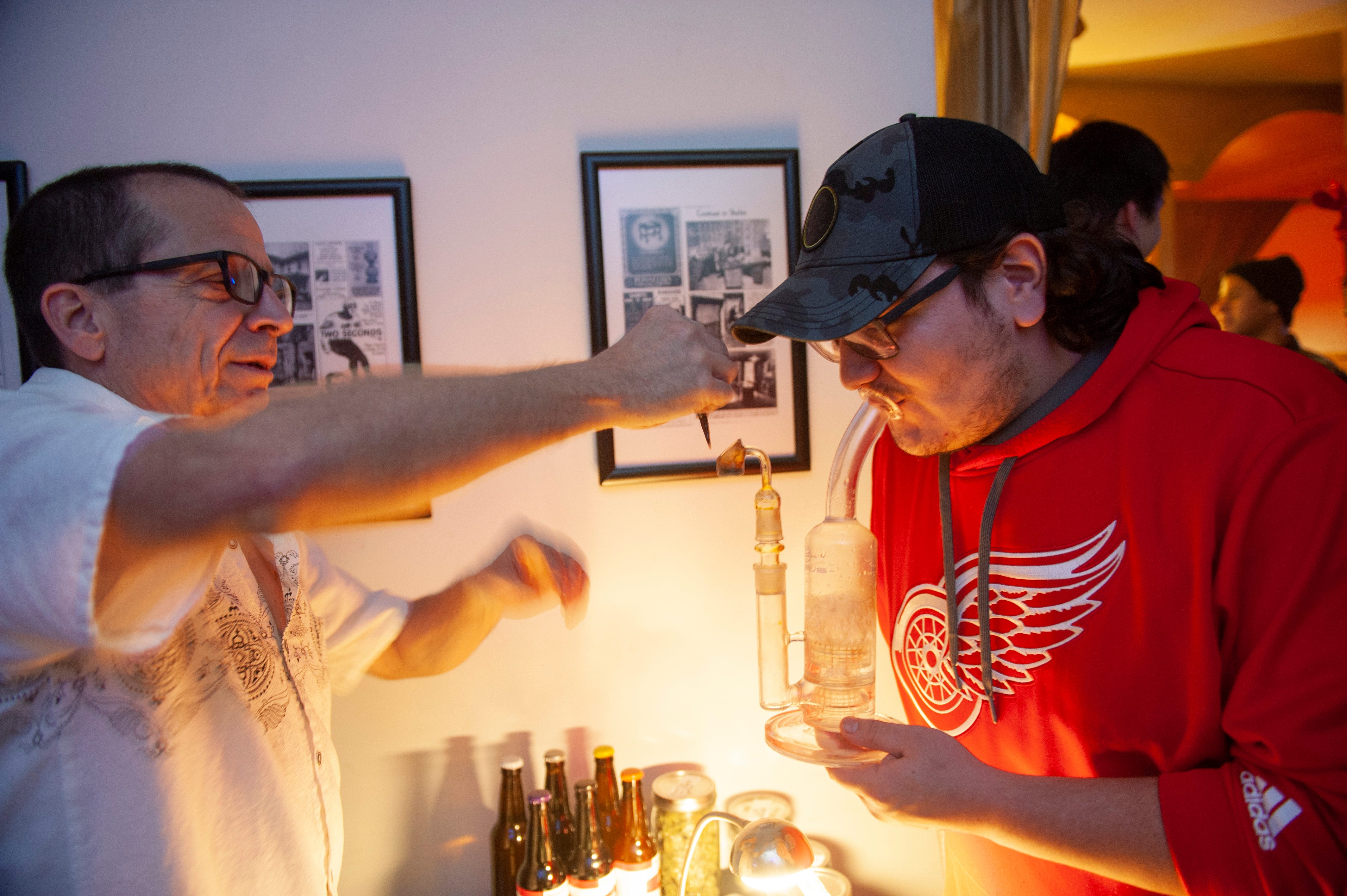 Cannabis entrepreneur Mike, left, offers a free "dab" to Peter of Oakland Township (both withheld their last names) during "The Art of Cannabis" event at the Cannabis Counsel in Detroit.