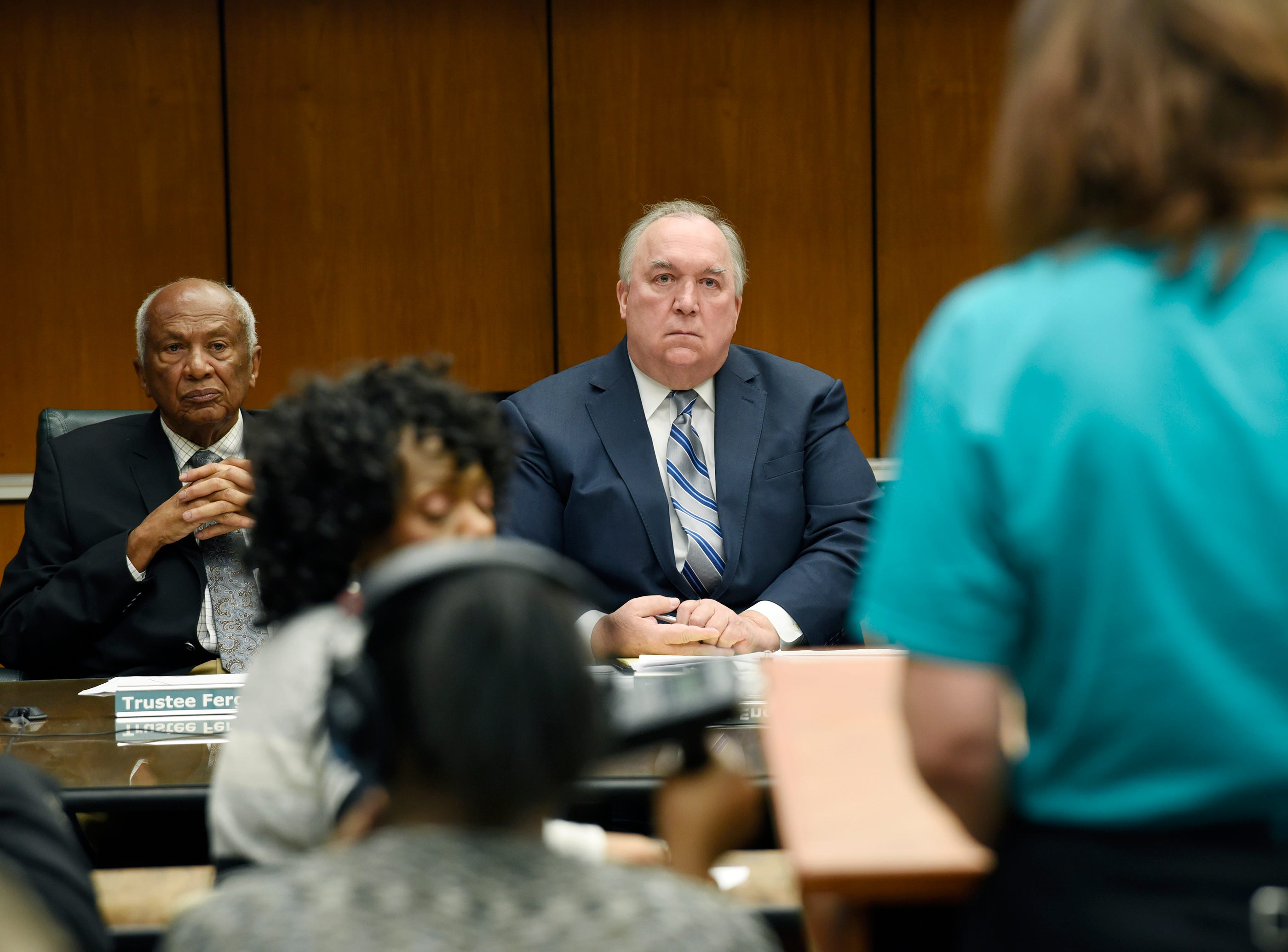 Interim President John Engler and trustee Joel Ferguson listen to a student during the public comment portion of Michigan State University's Board of Trustees meeting on Wed., Jan. 9, 2018 in East Lansing.
