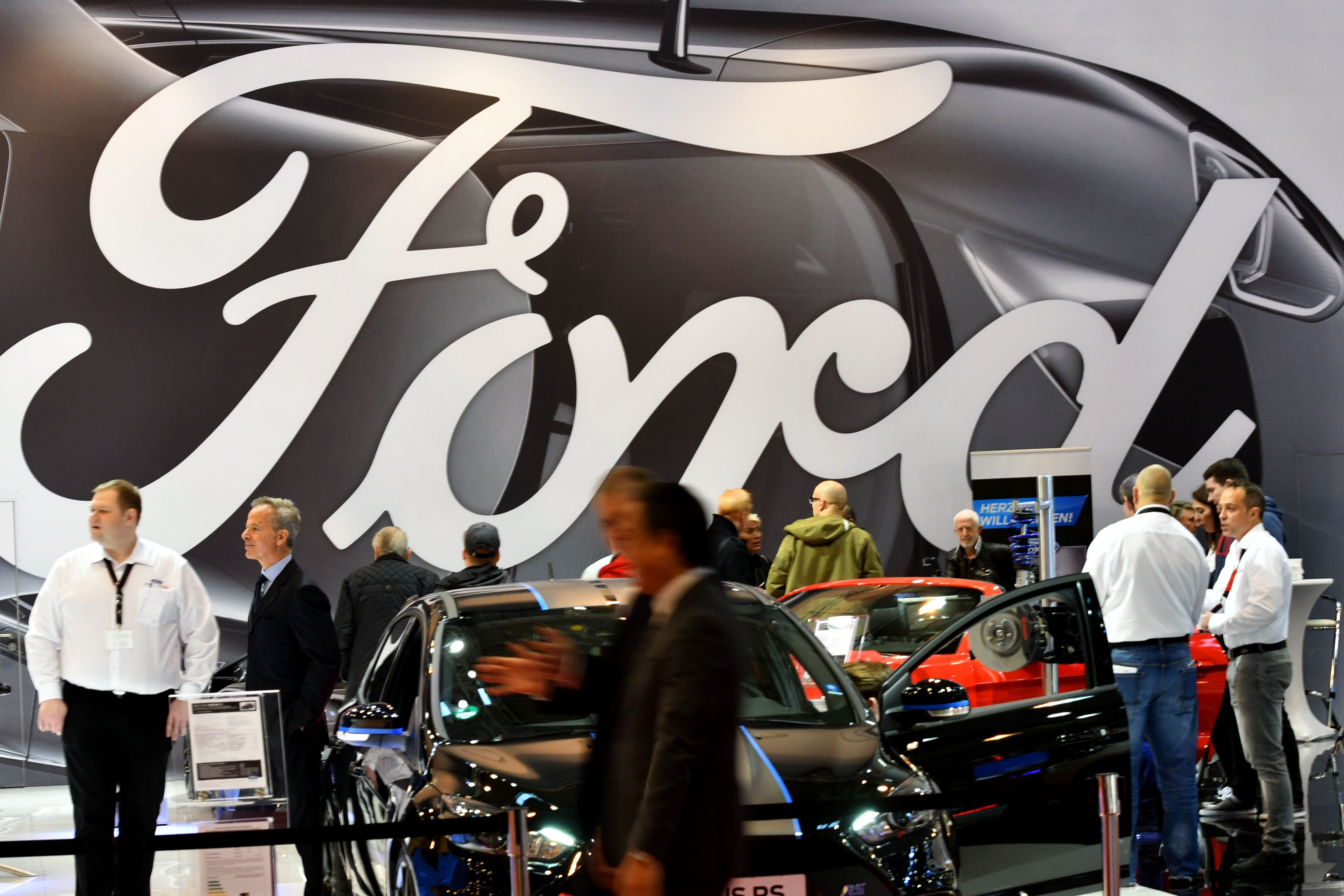 Visitors are seen at the stand of car maker Ford during the 'Essen Motor Show' fair in Essen, western Germany, on December 1, 2017.)