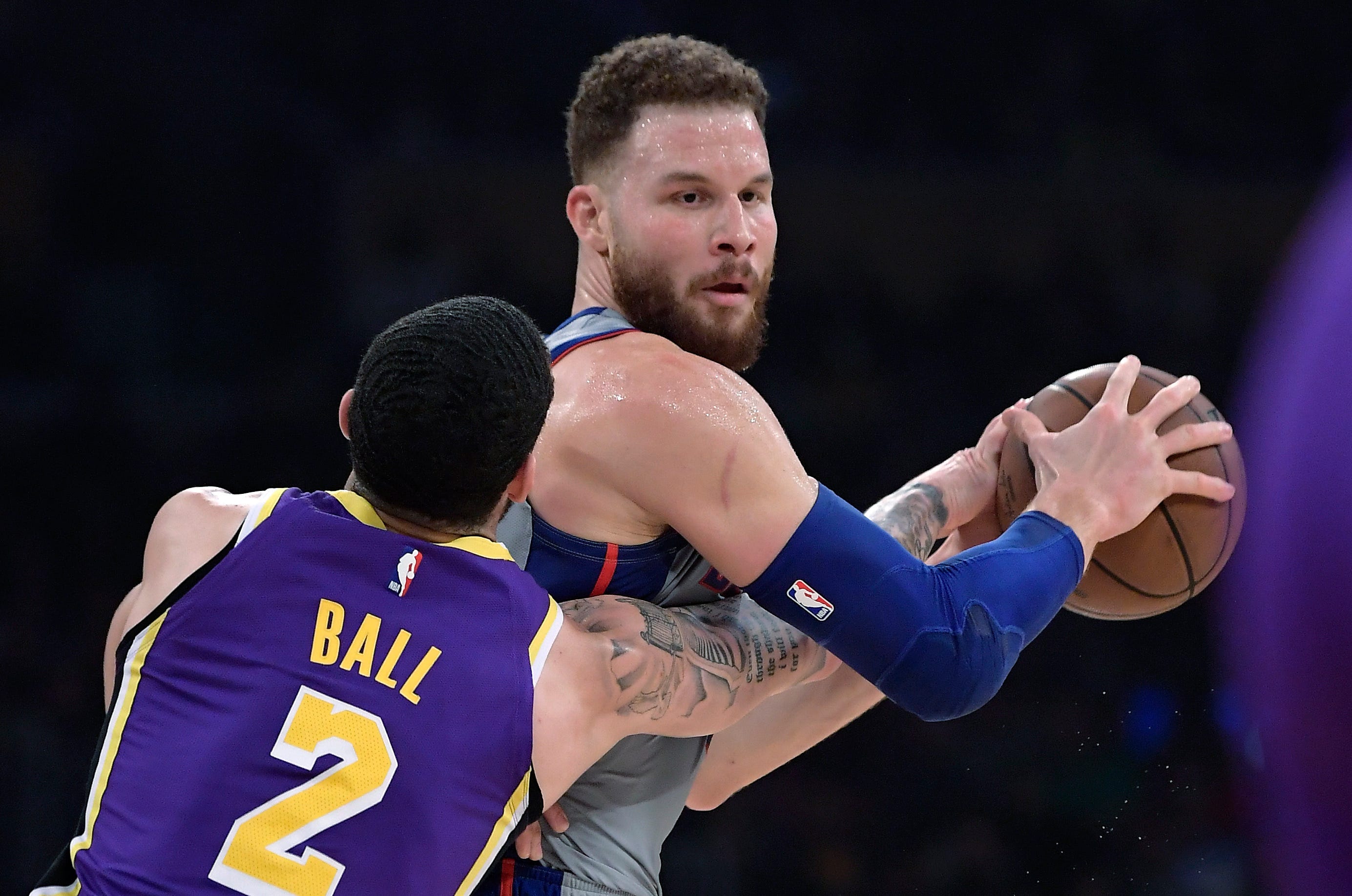 Los Angeles Lakers guard Lonzo Ball, left, reaches for the ball held by Detroit Pistons forward Blake Griffin during the first half.