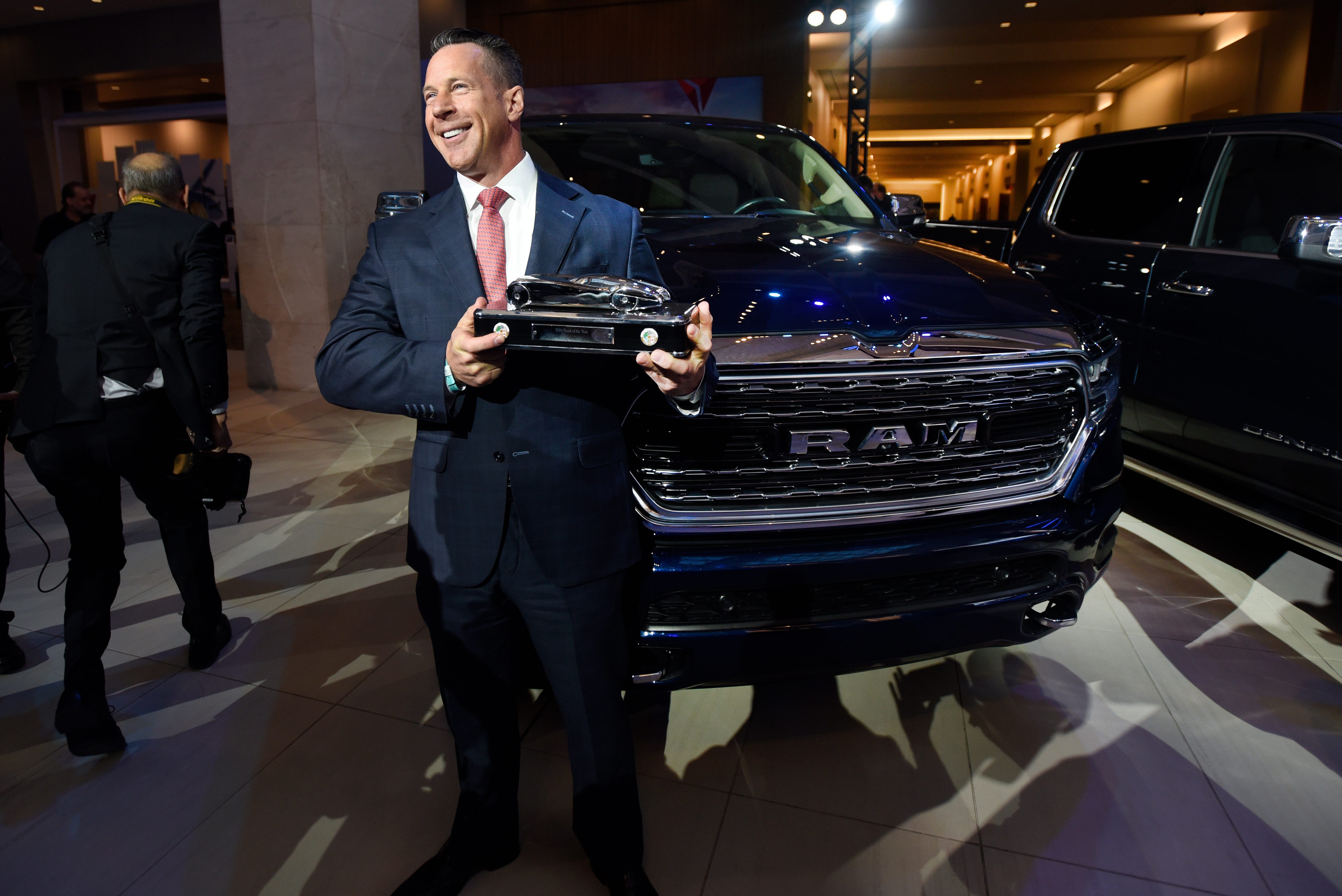 Reid Bigland, head of the Ram brand, shows off the Truck of the Year award next to the Ram 1500.