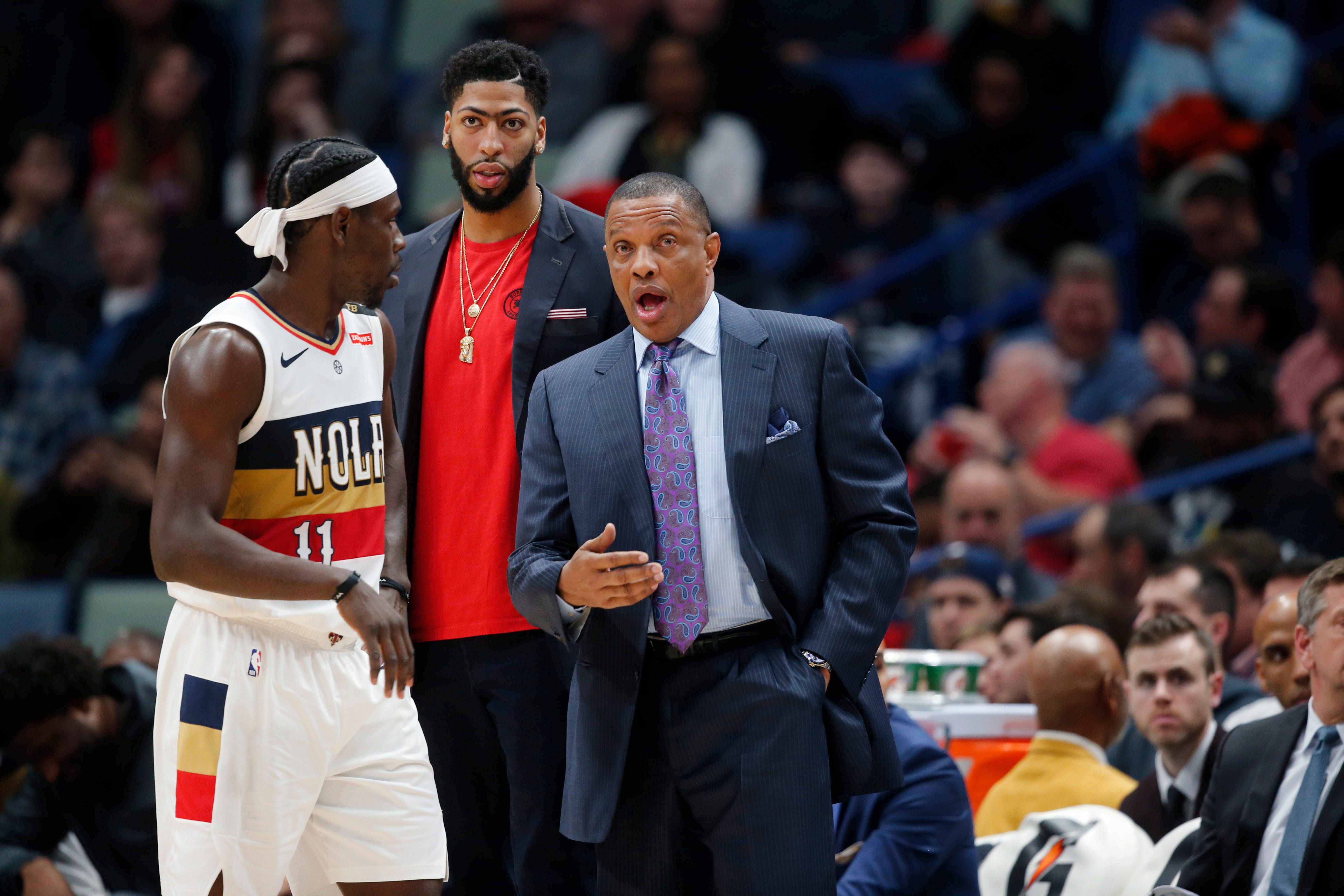 New Orleans Pelicans head coach Alvin Gentry talks to guard Jrue Holiday (11) and New Orleans Pelicans forward Anthony Davis, in street clothes due to an injury, in the second half of an NBA basketball game against the Detroit Pistons in New Orleans, Wednesday, Jan. 23, 2019. The Pistons won 98-94.