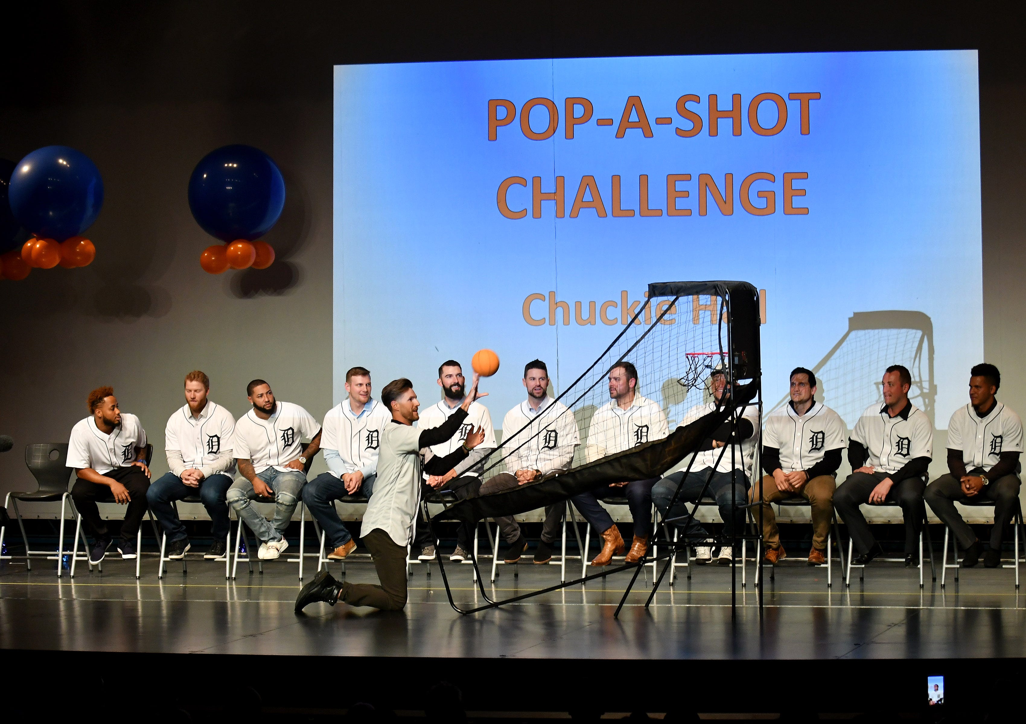 Tigers pitcher Shane Greene competes in a pop-a-shot challenge at a kids rally at Novi High School.