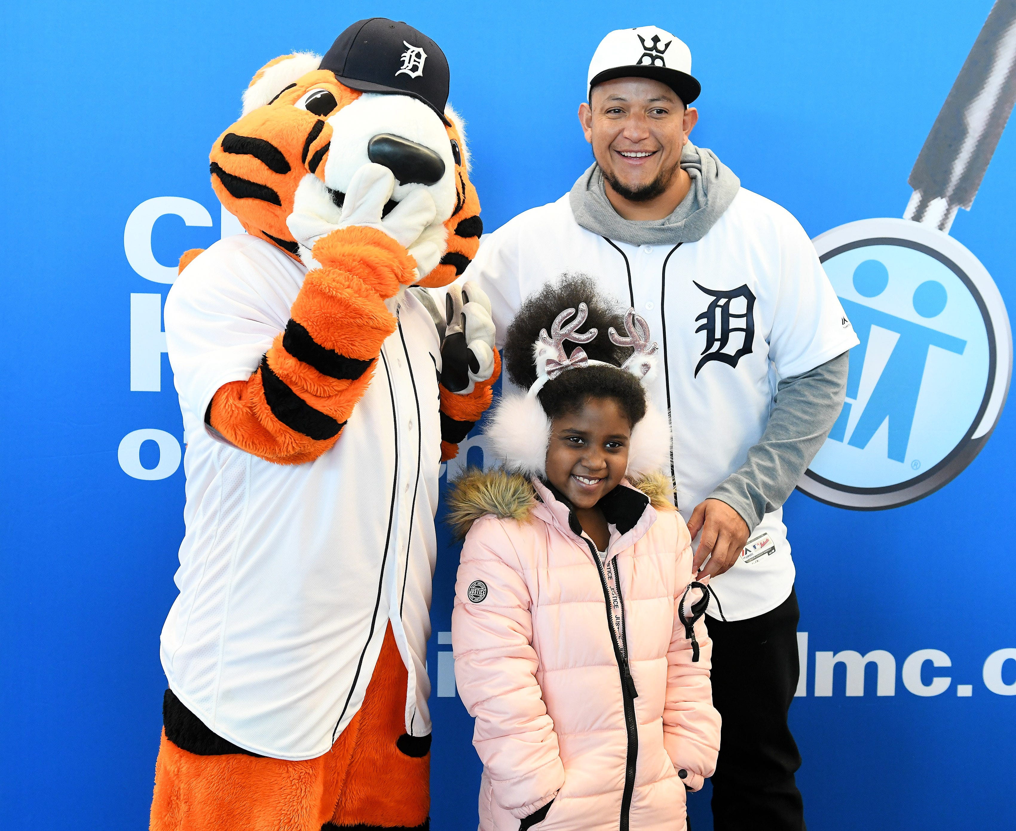 Tigers' Miguel Cabrera, right, has a photo taken with Paws and DaVeyna Perry-Stephens, 9, of Inkster who is recovering from brain surgery she had last month at the Children's Hospital of Michigan.