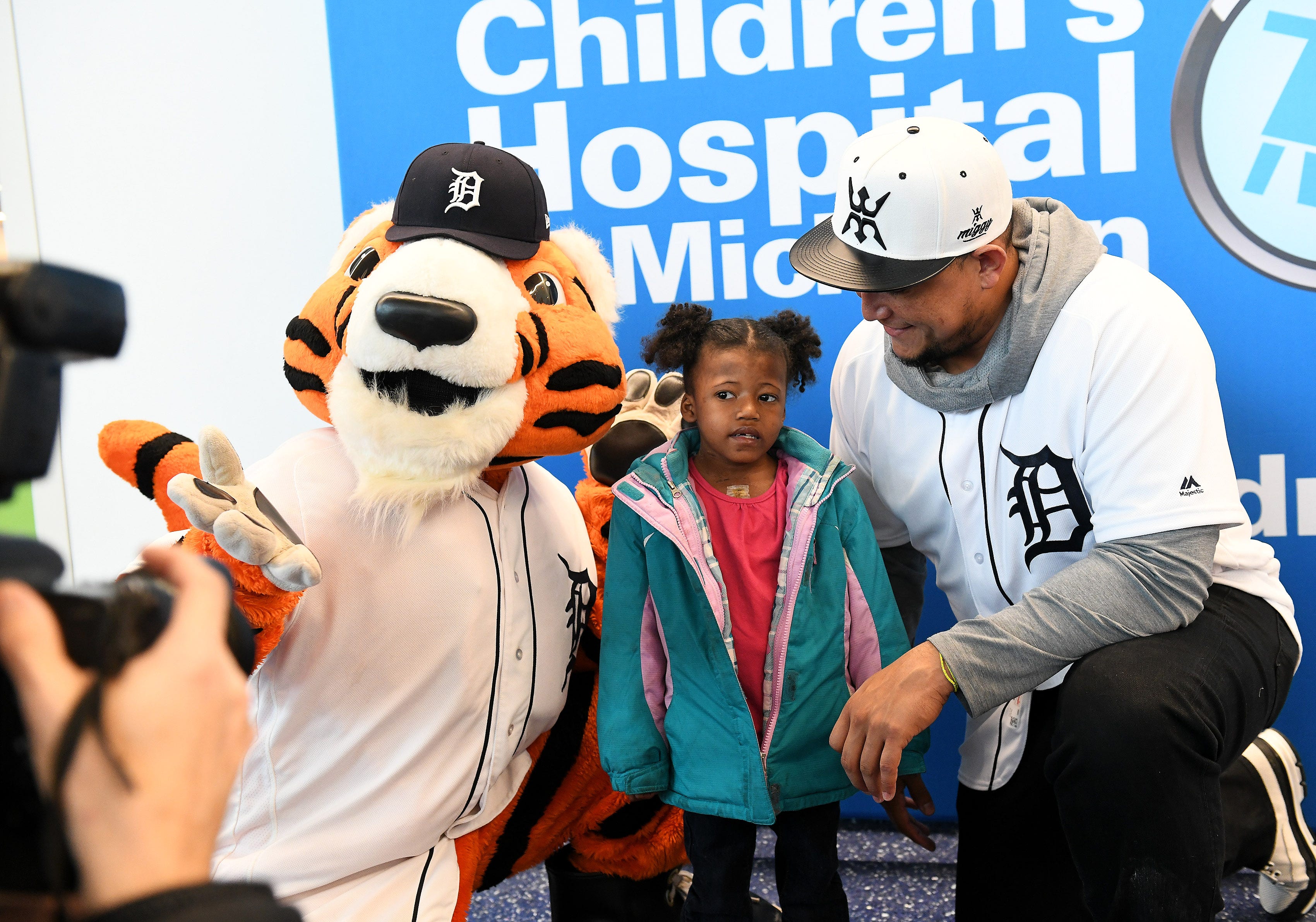 Tigers' Miguel Cabrera, right, has a photo taken with Paws and Marihanna Tillie, 5, of Detroit who is recovering from open heart surgery she had last week at the Children's Hospital of Michigan.