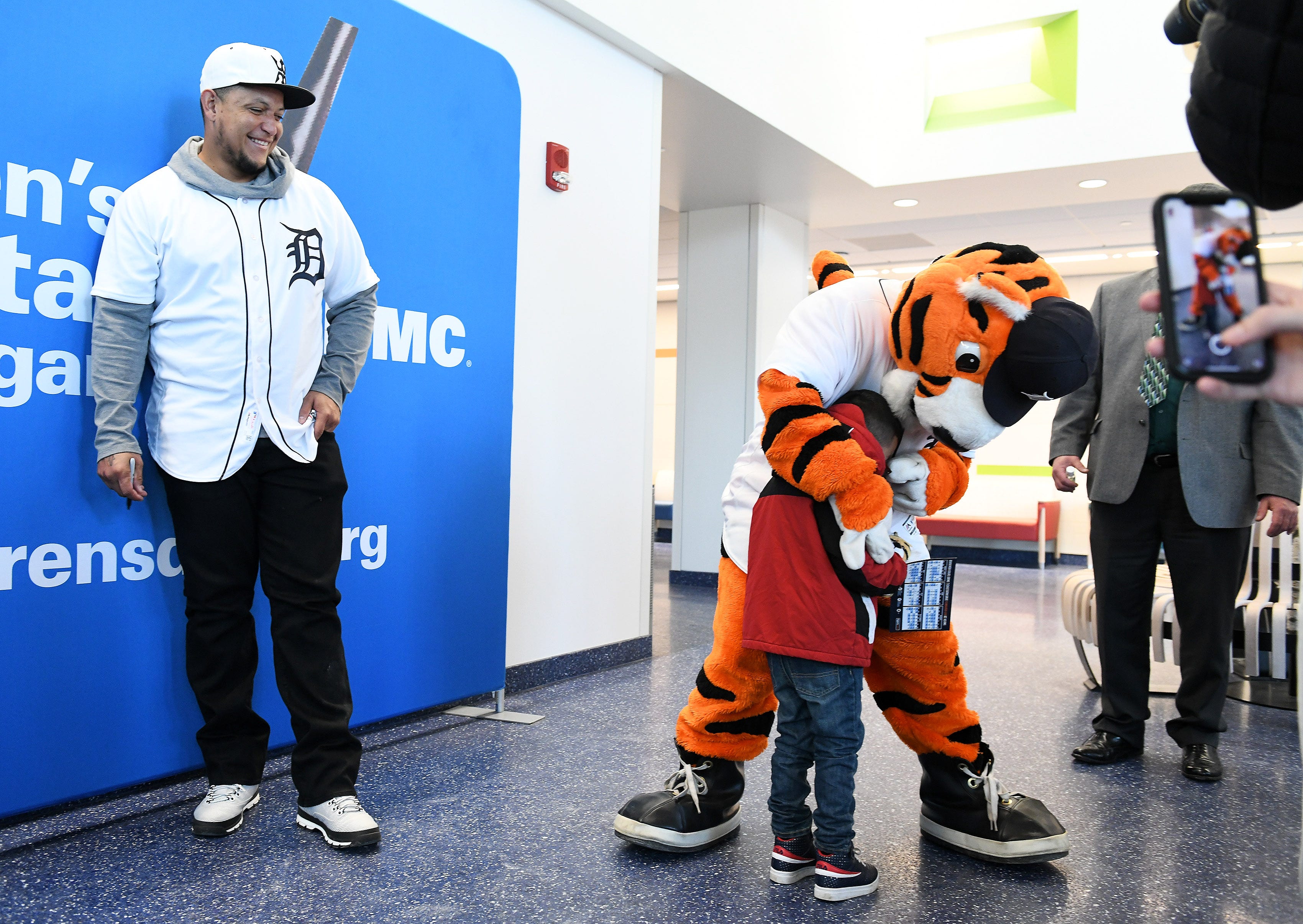 Tigers' Miguel Cabrera, left, laughs as Jesus Plata Gonzalez, 4, of Detroit goes to Paws before him during a stop on the 2019 Detroit Tigers Winter Caravan at the Children's Hospital of Michigan  in Detroit on Jan. 25, 2019.