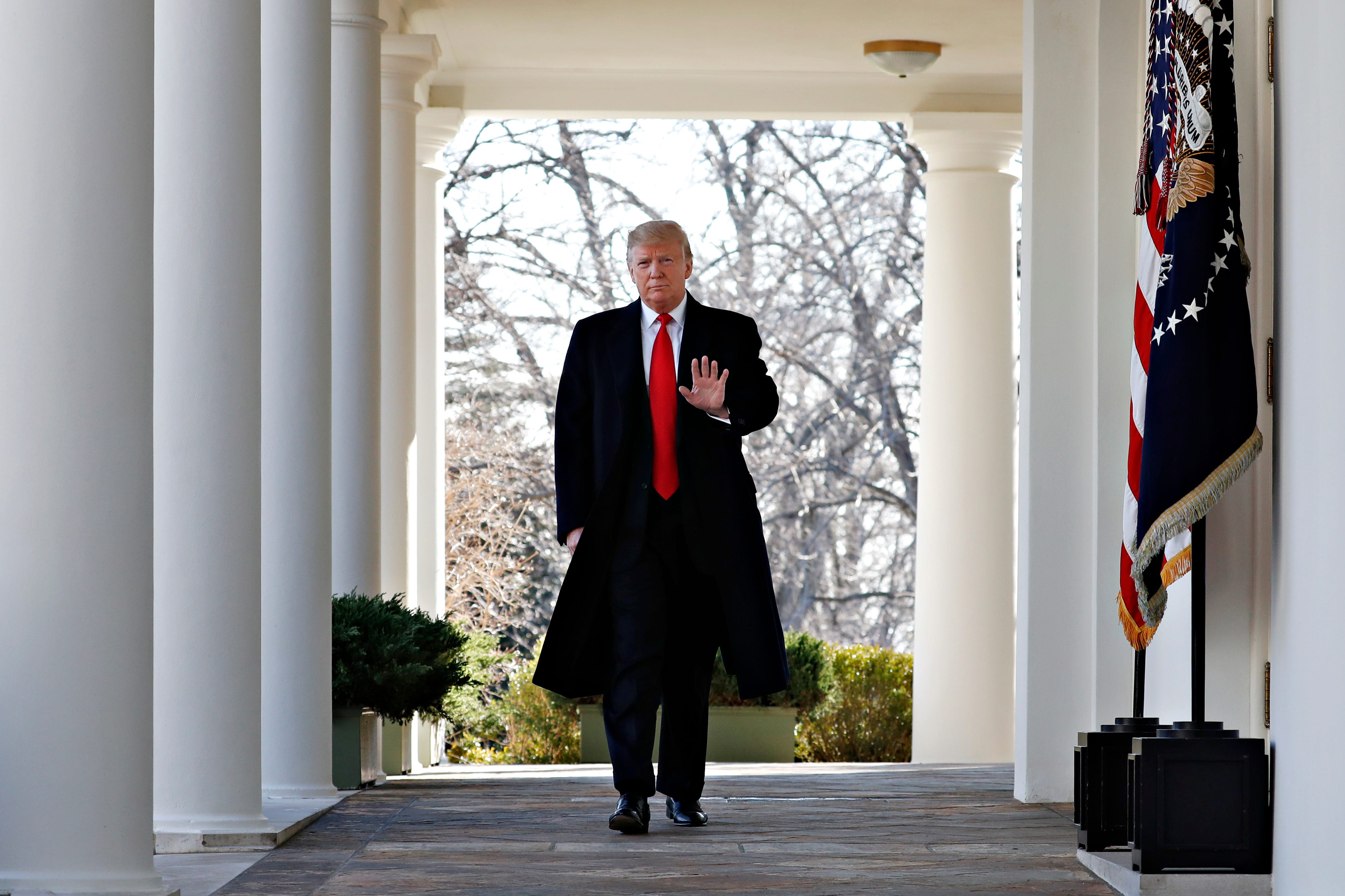 President Donald Trump waves as he walks through the Colonnade  from the Oval Office of the White House on arrival to announce a deal to temporarily reopen the government, Friday, Jan. 25, 2019, from the Rose Garden of the White House in Washington.