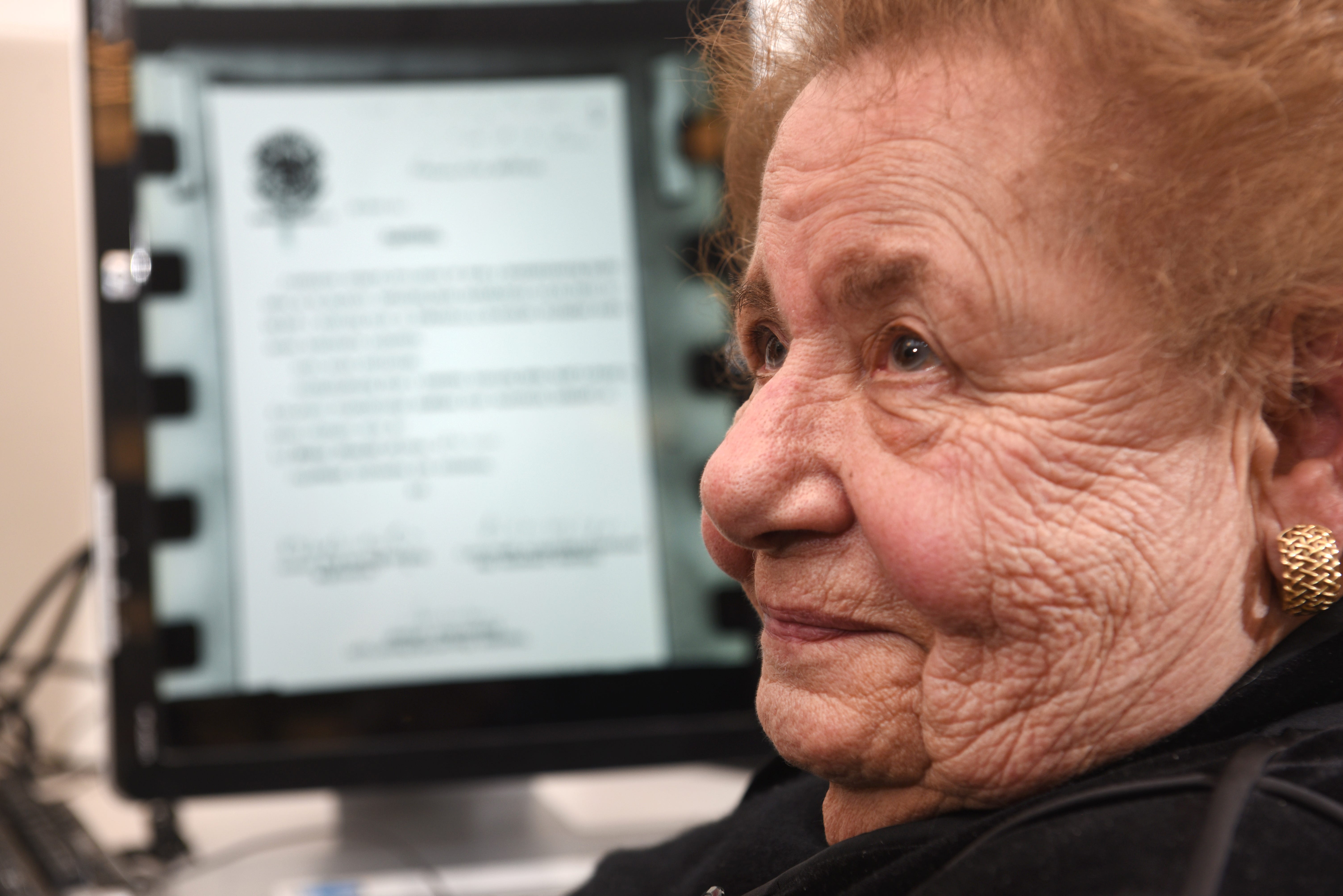 Clara Garbon-Rednoti, a Holocaust survivor, examines and reads documents on micro-film in the library of the Holocaust Memorial Museum in Farmington Hills.