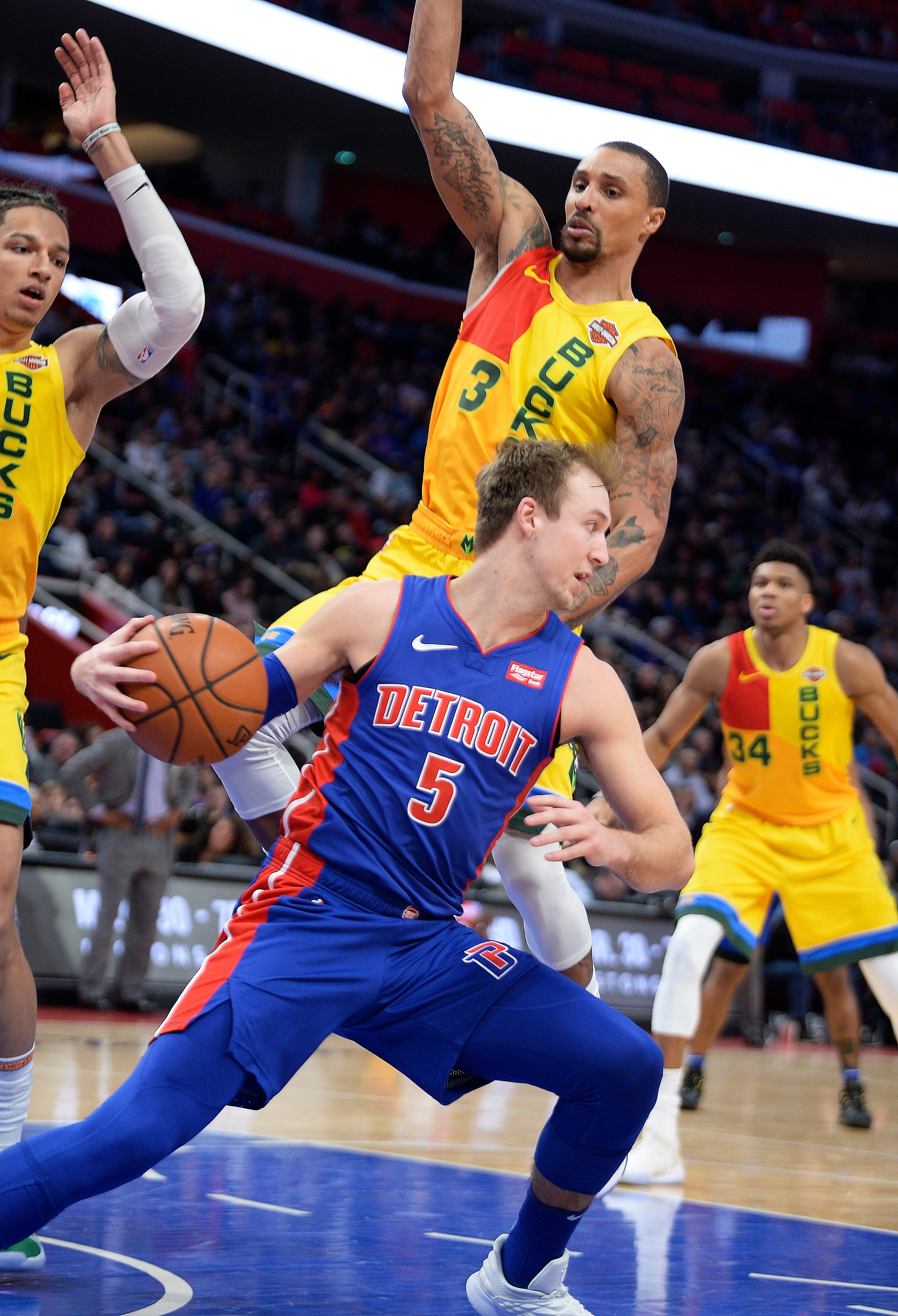 Pistons' Luke Kennard looks for room around Bucks' l-r, D.J. Wilson and George Hill in the fourth quarter.